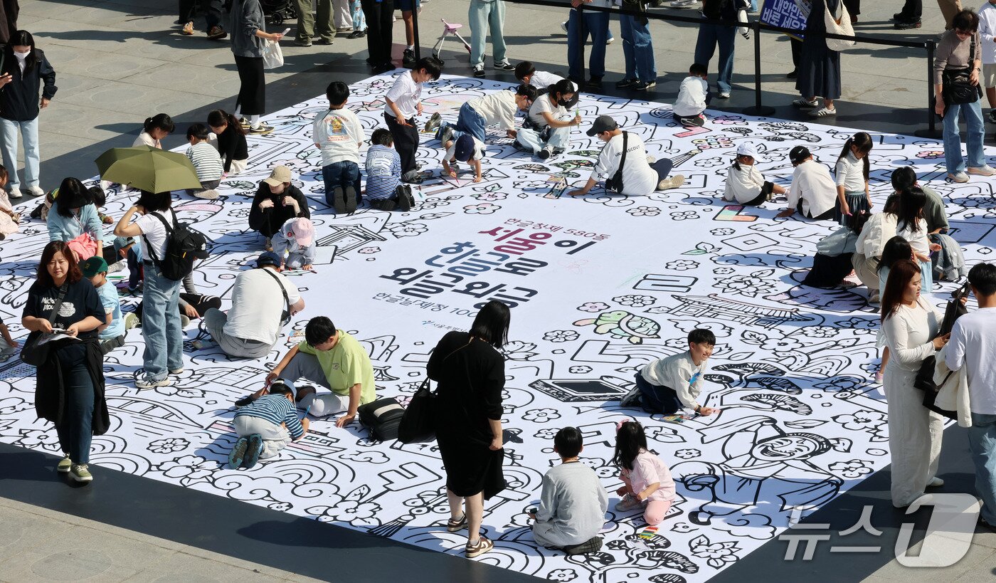 본문 이미지 - 한글날인 9일 서울 광화문광장에서 열린 '서울이 한글로 와글와글' 행사를 찾은 어린이들이 한글색칠마당에서 색칠을 하고 있다. 2026.10.9 ⓒ 뉴스1 박세연 기자