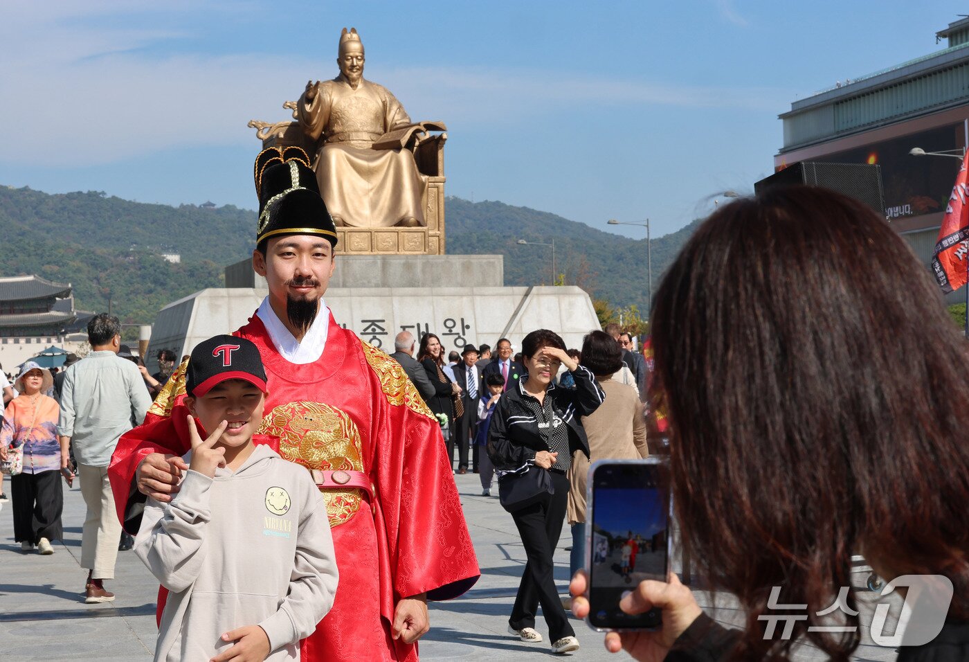 본문 이미지 - 한글날인 9일 서울 광화문광장에서 열린 '서울이 한글로 와글와글' 행사를 찾은 어린이가 세종대왕 복장의 연기자와 사진을 찍고 있다. 2026.10.9 ⓒ 뉴스1 박세연 기자