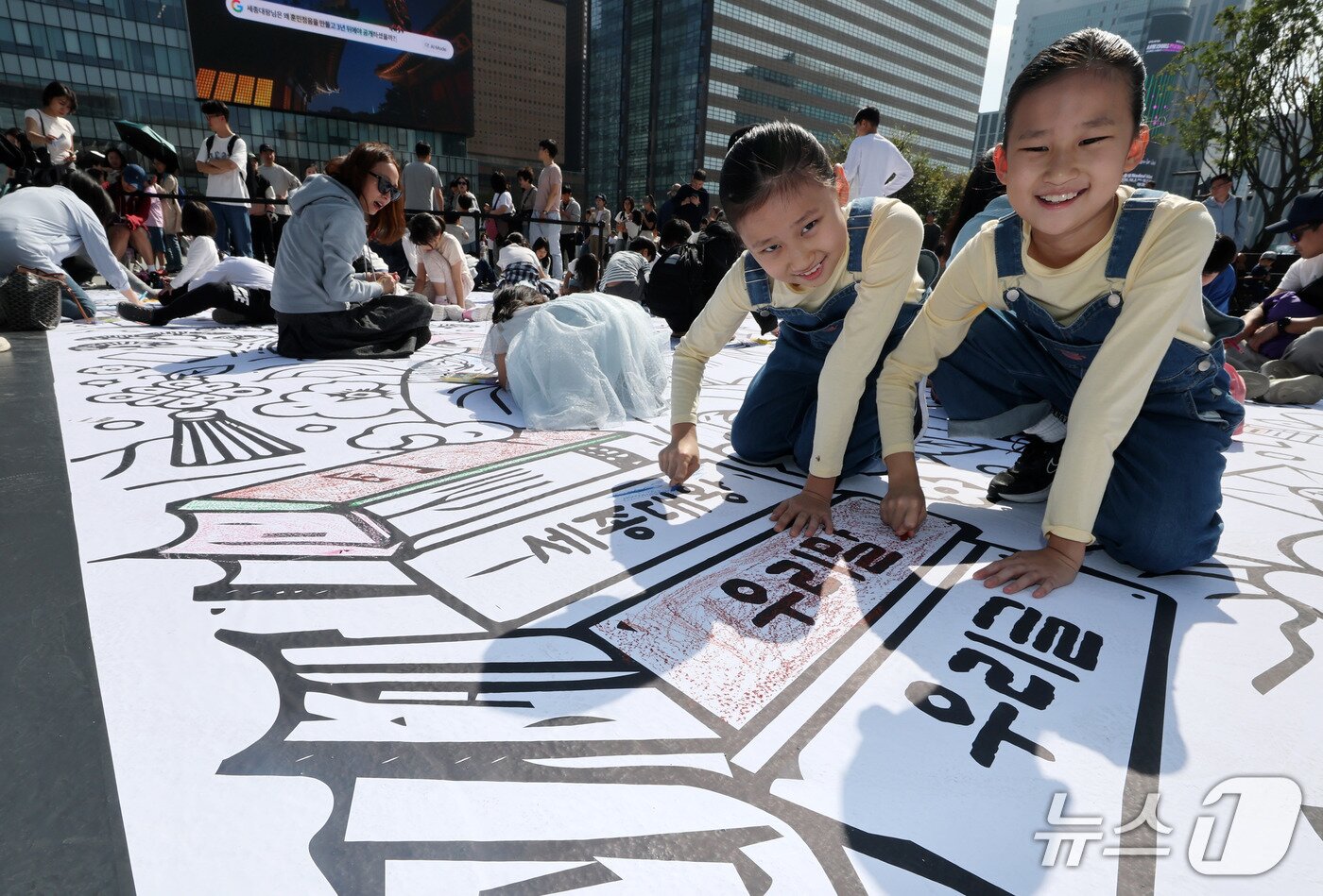 본문 이미지 - 한글날인 9일 서울 광화문광장에서 열린 '서울이 한글로 와글와글' 행사를 찾은 어린이들이 한글색칠마당에서 색칠을 하고 있다. 2026.10.9 ⓒ 뉴스1 박세연 기자