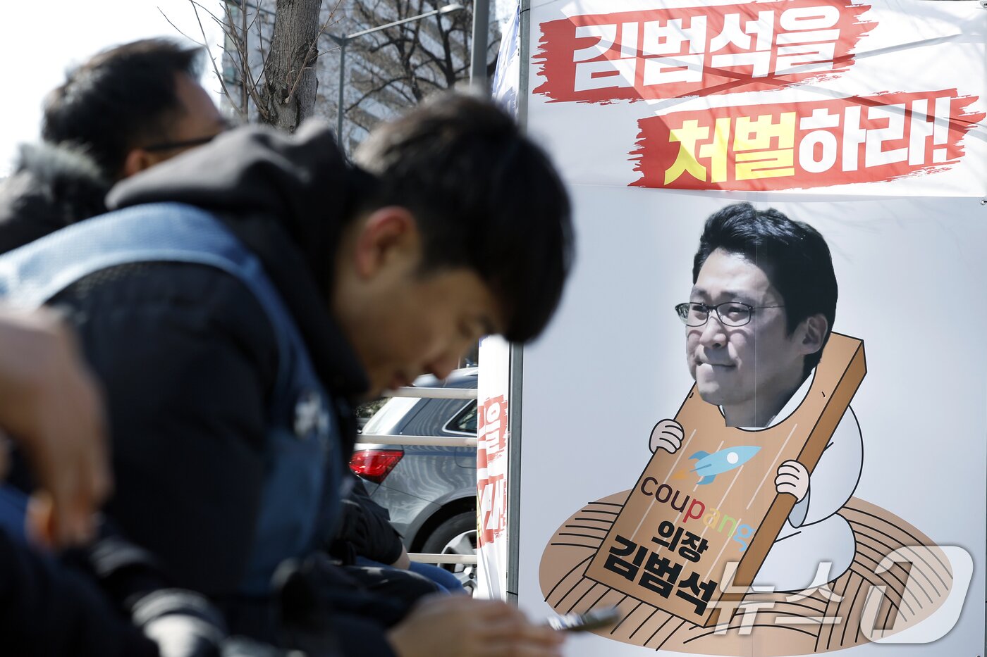 본문 이미지 - 지난 1일 오후 서울 송파구 송파대로 쿠팡 본사 앞에서 열린 택배노조 쿠팡 규탄대회장 옆에 칼을 채운 쿠팡 김범석 의장 사진이 설치되어 있다. 2026.2.1 / ⓒ 뉴스1 박정호 기자