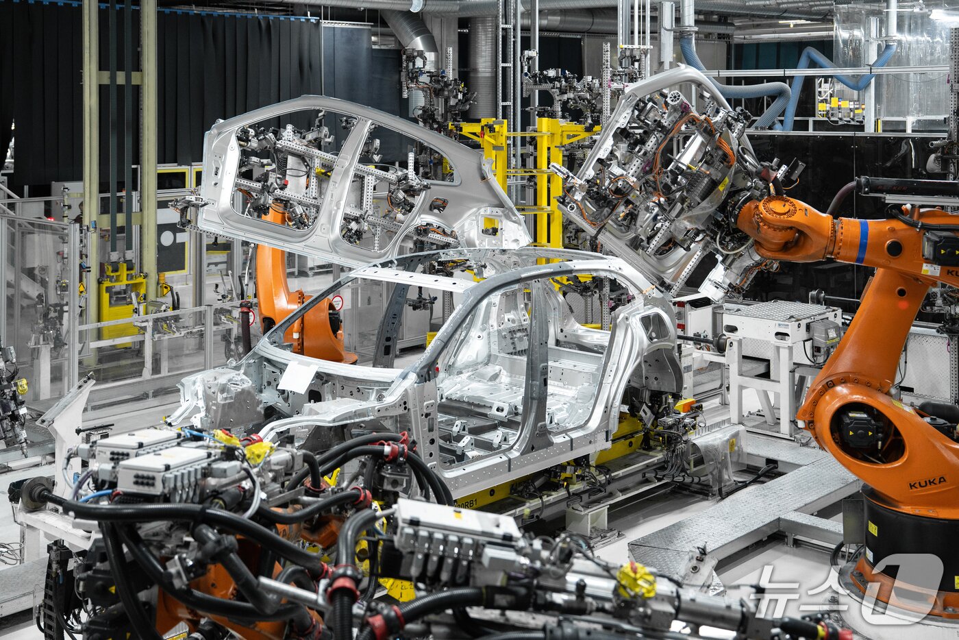 본문 이미지 - 지난달 28일(현지시각) 슬로바키아 수도 브라티슬라바 외곽의 폭스바겐그룹 공장 내 카이엔 일렉트릭 전용 플랫폼 홀에서 올해 하반기 출시되는 포르쉐 준대형 전기 SUV '카이엔 일렉트릭'의 차체와 차대가 로봇팔에 의해 만들어지고 있는 모습(포르쉐 제공). 2026.01.28.