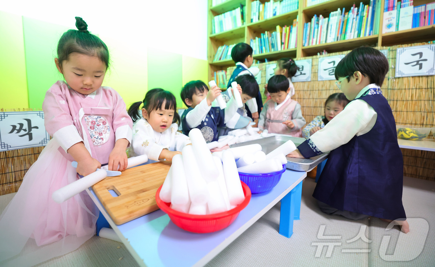 (서울=뉴스1) = 설 명절을 일주일 앞둔 10일 경남 함양군 성민어린이집 원생들이 예쁜 전통한복을 차려입고 가래떡 썰기 놀이를 하고 있다. (함양군 제공. 재판매 및 DB 금지) …