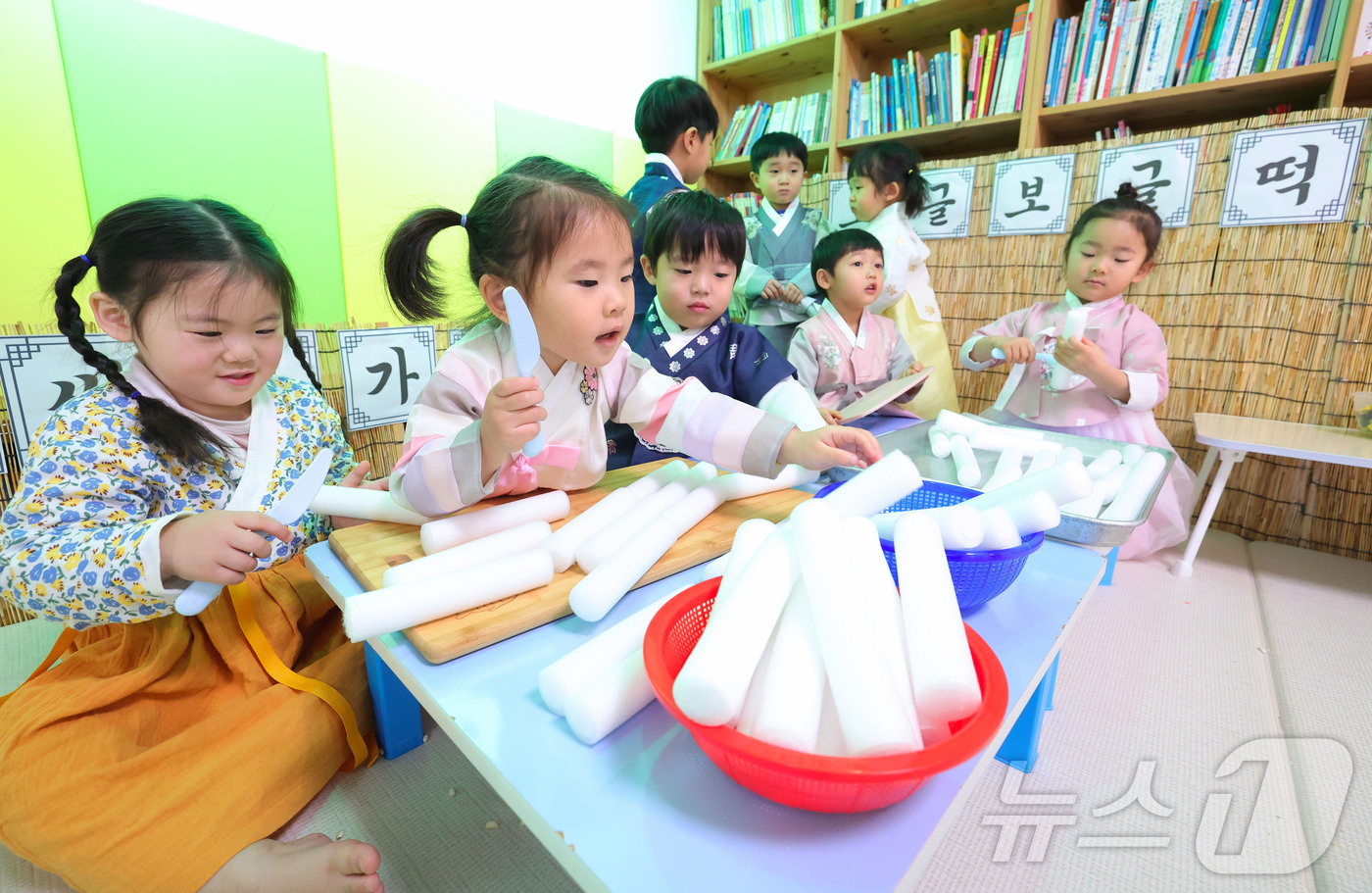 (서울=뉴스1) = 설 명절을 일주일 앞둔 10일 경남 함양군 성민어린이집 원생들이 예쁜 전통한복을 차려입고 가래떡 썰기 놀이를 하고 있다. (함양군 제공. 재판매 및 DB 금지) …