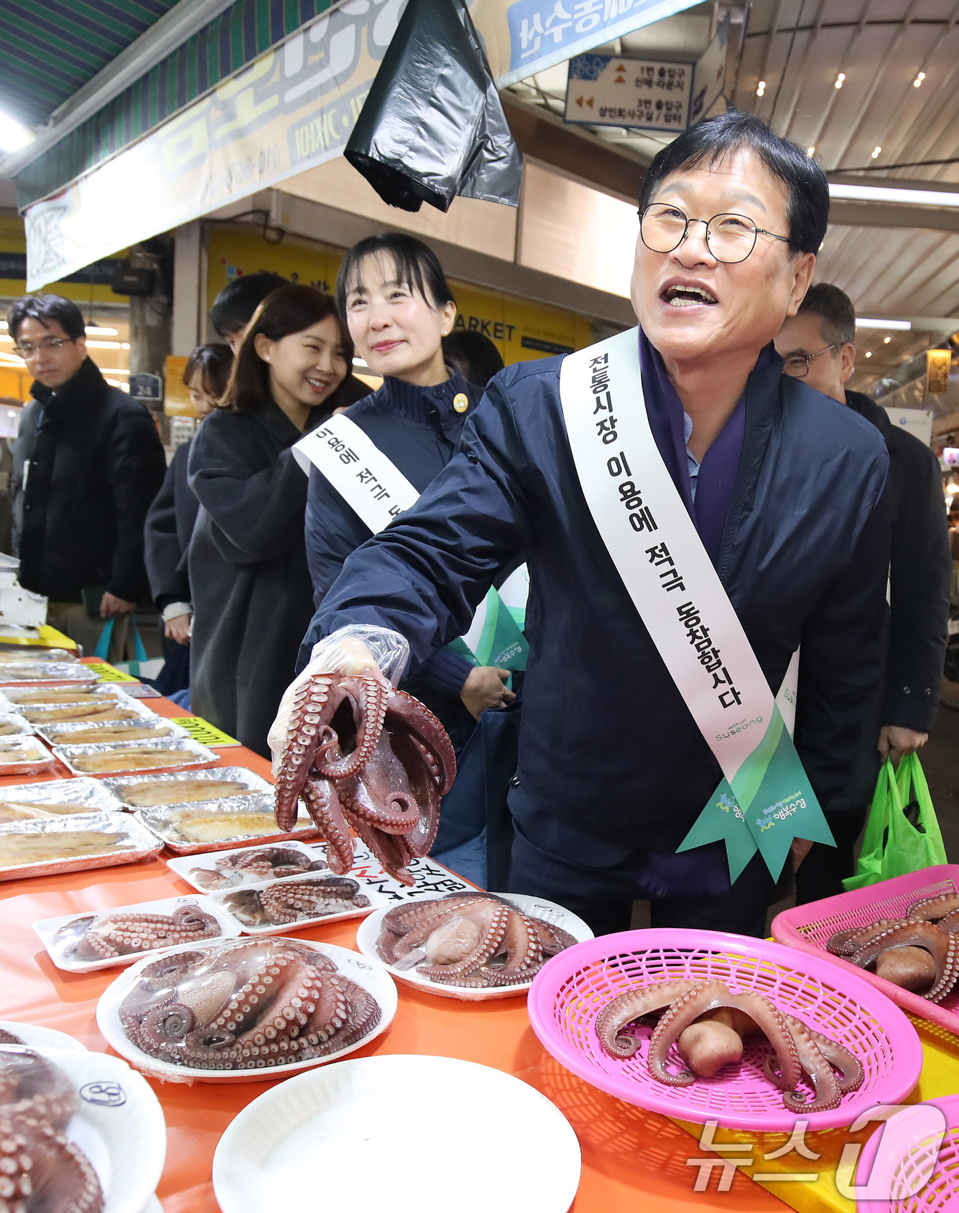(대구=뉴스1) 공정식 기자 = 10일 오후 대구 수성구 신매시장에서 열린 '설맞이 전통시장 장보기' 행사에 참여한 김대권 수성구청장과 구청 직원들이 어물전에서 제수용 문어를 고르 …