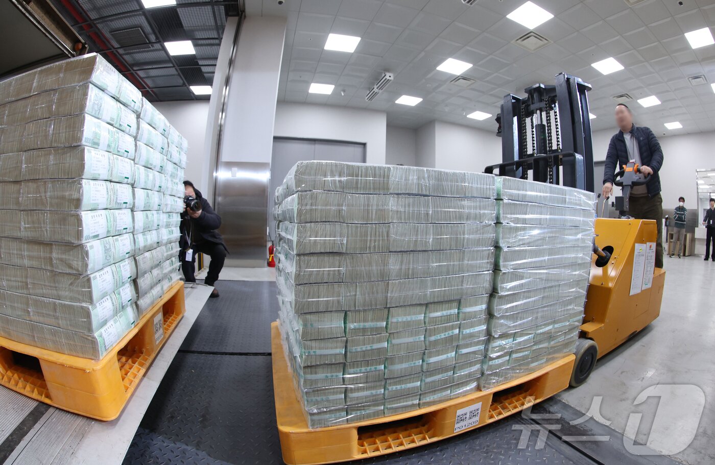 본문 이미지 - 설날을 앞둔 11일 서울 중구 한국은행 본점에서 현금 운송 관계자들이 시중은행에 공급될 설 자금 방출 작업을 하고 있다. 2026.2.11 ⓒ 뉴스1 사진공동취재단