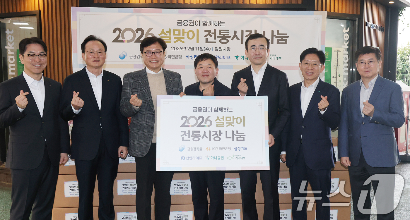 (서울=뉴스1) 오대일 기자 = 11일 오전 서울 마포구 망원시장에서 열린 2026 금융권이 함께하는 설 맞이 전통시장 나눔행사에서 참석자들이 기념촬영을 하고 있다. 왼쪽부터 천상 …