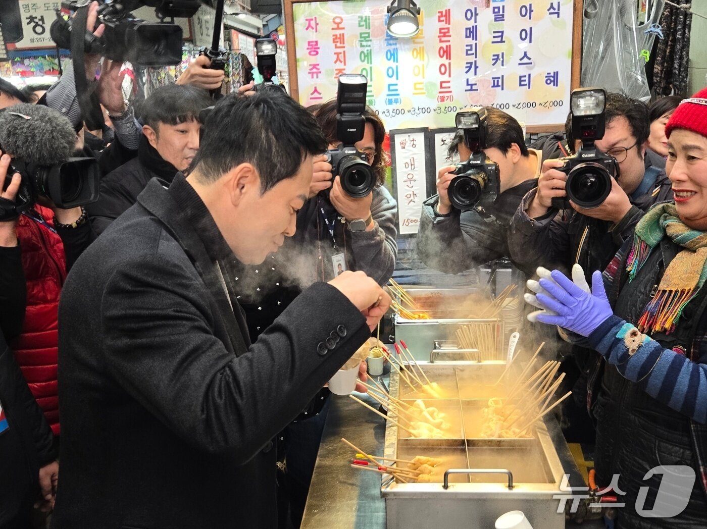 본문 이미지 - 장동혁 국민의힘 대표가 11일 대구 서문시장에서 어묵을 먹고 있다. 2026.02.11. ⓒ 뉴스1  손승환 기자