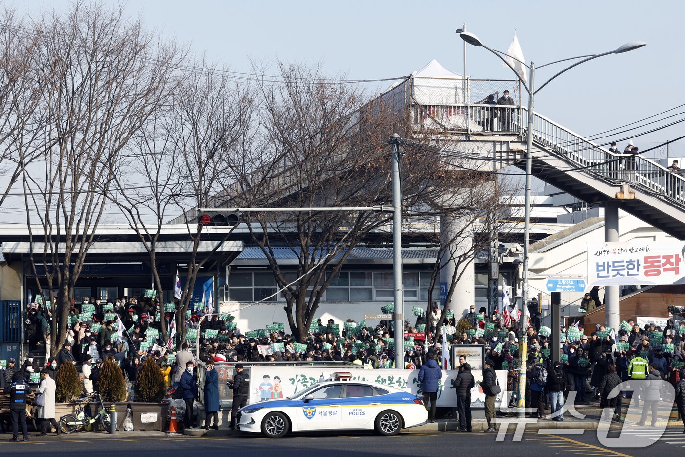 본문 이미지 - 이재명 대통령과 김현지 청와대제1부속실장에 대한 허위 사실을 유포한 혐의로 고발된 한국사 강사 출신 보수 유튜버 전한길 씨 지지자들이 12일 오전 서울시 동작구 노량진역 앞에서 전 씨의 피의자 신분 경찰 첫 소환 조사 출석에 앞서 열린 기자회견에서 손피켓을 들어 환호하고 있다.  2026.2.12 ⓒ 뉴스1 박정호 기자