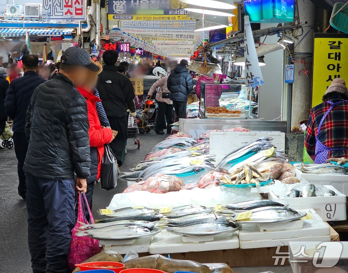 본문 이미지 - 설 연휴를 이틀 앞둔 12일 마산어시장을 찾은 손님들이 생선을 둘러보고 있다. 2026.2.12 ⓒ 뉴스1 박민석 기자