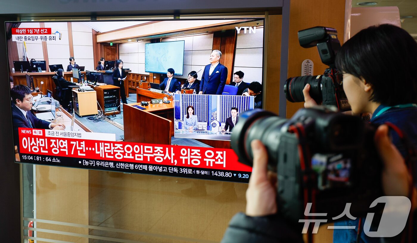 본문 이미지 - 12·3 비상계엄 당시 언론사 단전·단수 지시 혐의를 받는 이상민 전 행정안전부 장관의 1심 선고일인 12일 서울역 대합실에서 선고 생중계가 나오는 가운데 재판부가 징역 7년을 선고하고 있다. 2026.2.12 ⓒ 뉴스1 안은나 기자