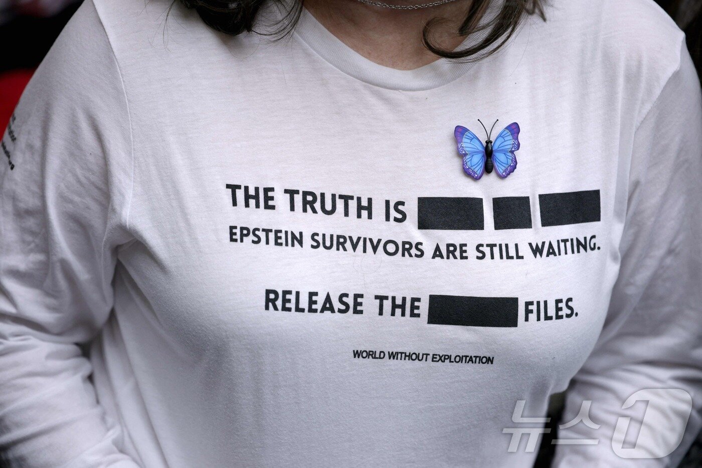 본문 이미지 - 11일(현지시간) 미국 워싱턴DC에서 열린 하원 법사위원회 청문회에 팸 본디 미 법무장관이 출석해 증언하는 가운데, 성범죄자 제프리 엡스타인의 피해자가 참석해 지켜보고 있다. 피해자가 입은 옷에 "진실은 아직 가려져 있다. 엡스타인 피해 생존자들은 여전히 정의를 기다리고 있다. 관련 파일을 전면 공개하라. 착취 없는 세상을 위하여＂라는 문구가 적혀 있다. 2026.02.11. ⓒ AFP=뉴스1