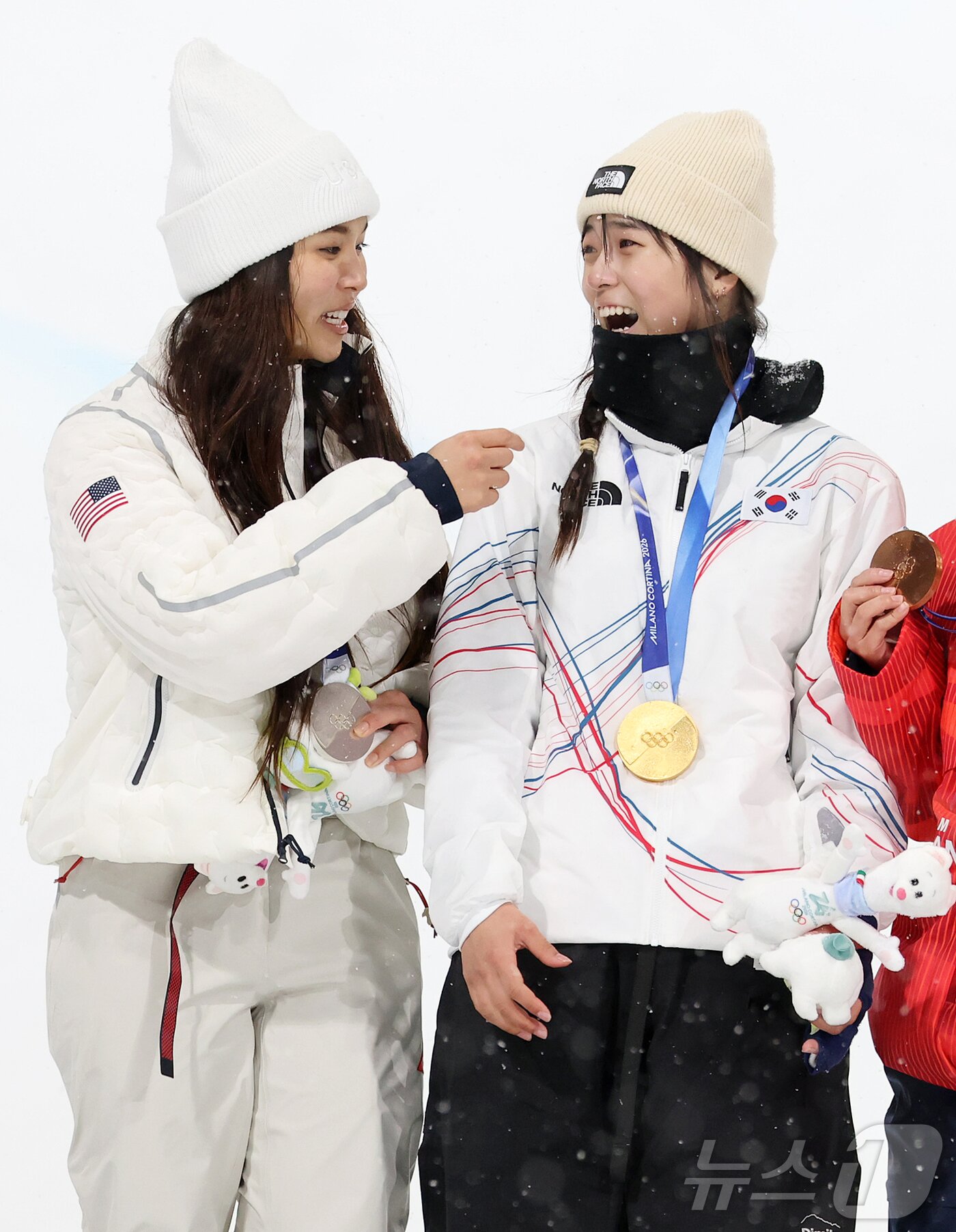 본문 이미지 - 12일(현지시간) 이탈리아 리비뇨 스노파크에서 열린 2026 밀라노·코르티나담페초 동계올림픽 스노보드 여자 하프파이프 결선에서 90.25점을 받아 금메달을 획득한 스노보드 최가온이 은메달을 획득한 미국의 클로이 킴과 기쁨을 나누고 있다. 2026.2.13 ⓒ 뉴스1 김진환 기자