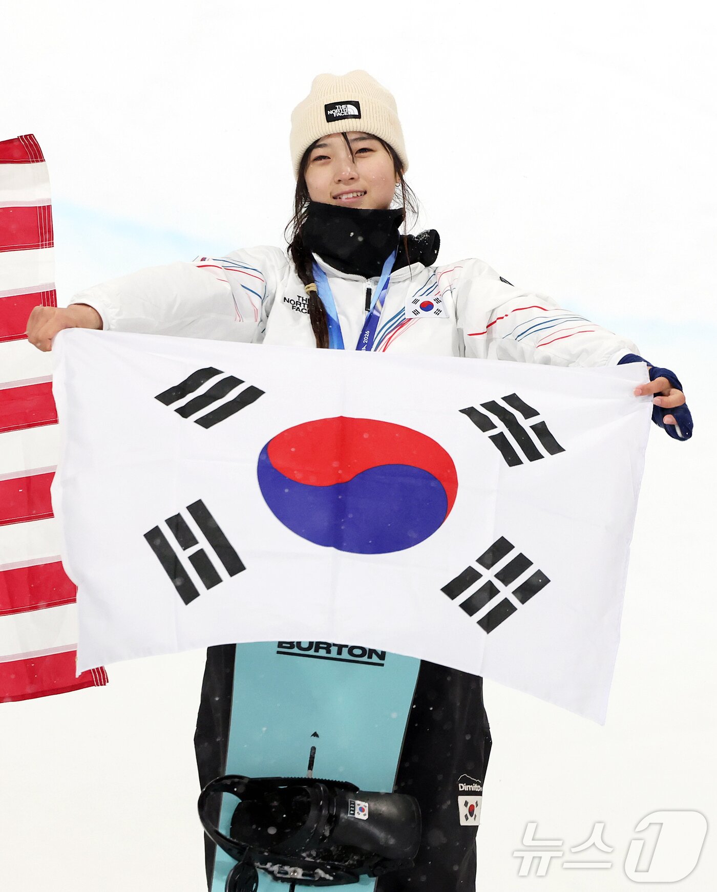 본문 이미지 - 12일(현지시간) 이탈리아 리비뇨 스노파크에서 열린 2026 밀라노·코르티나담페초 동계올림픽 스노보드 여자 하프파이프 결선에서 90.25점을 받아 금메달을 획득한 스노보드 최가온이 태극기를 들고 기뻐하고 있다. 2026.2.13 ⓒ 뉴스1 김진환 기자