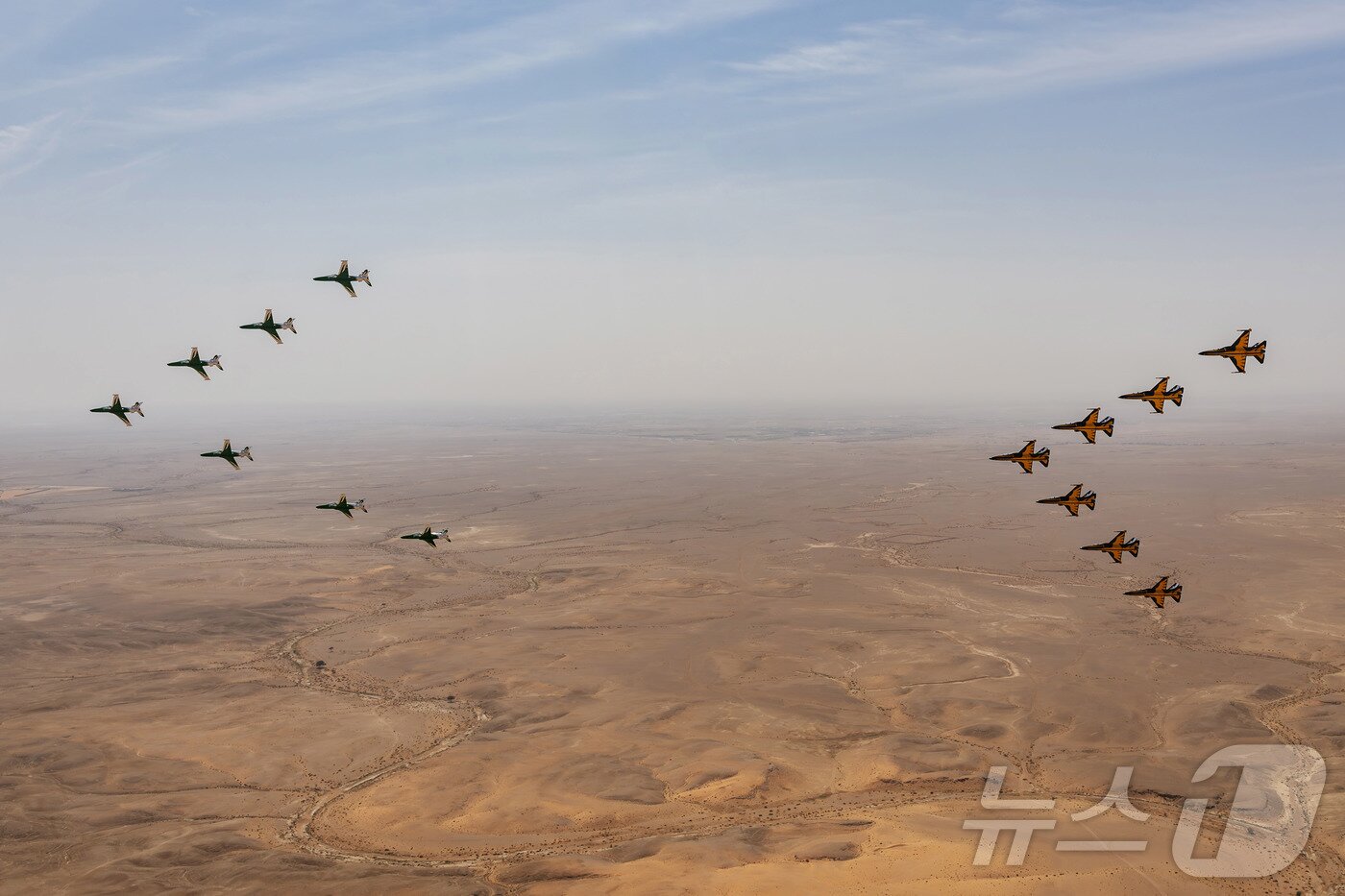 본문 이미지 - 공군은 특수비행팀 블랙이글스가 8일부터 12일(현지시간)까지 사우디아라비아 리야드에서 열린 ‘세계 방위산업 전시회(WDS 2026)’에 참가해 에어쇼를 선보였다고 13일 밝혔다. 사진은 지난 10일(현지시간) 진행된 '블랙이글스-사우디아라비아 호크스 우정비행 행사'에서 한국 블랙이글스 T-50B 7대(오른쪽)와 사우디 호크스 항공기 7대가 리야드 컨벤션 센터 상공에서 나란히 비행하는 모습. (공군 제공. 재판매 및 DB 금지) 2026.2.13 ⓒ 뉴스1
