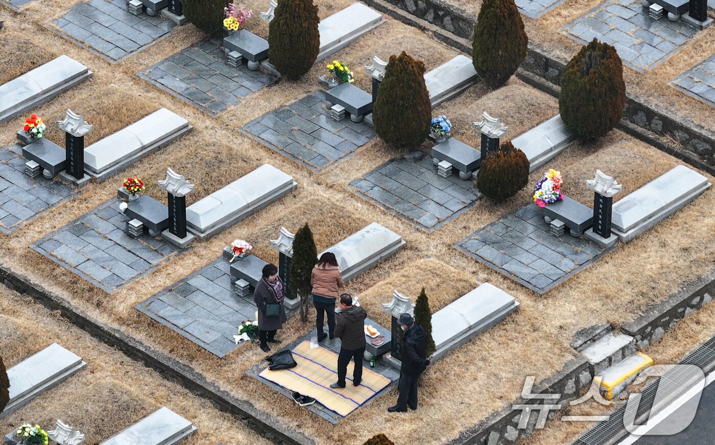 본문 이미지 - 설날을 닷새 앞둔 12일 인천 부평구 인천가족공원을 찾은 한 가족이 성묘하고 있다. 2026.2.13 ⓒ 뉴스1 김도우 기자