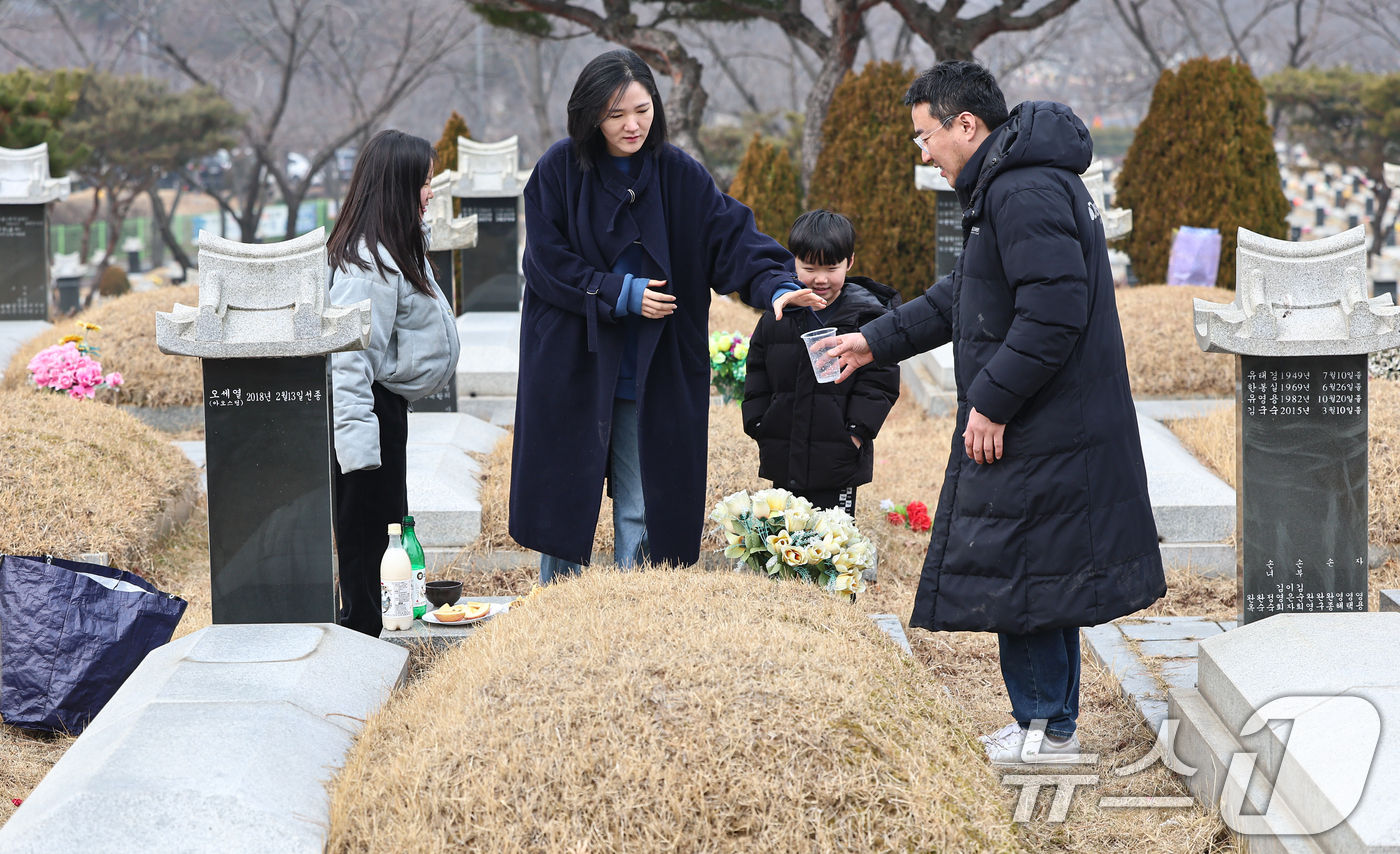 (인천=뉴스1) 김도우 기자 = 설날을 닷새 앞둔 12일 인천 부평구 인천가족공원을 찾은 한 가족이 성묘하고 있다. 2026.2.13/뉴스1