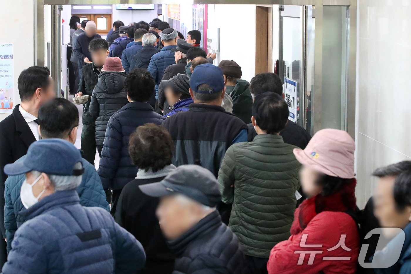 (대구=뉴스1) 공정식 기자 = 설 연휴를 하루 앞둔 13일 오전 대구 달서구 성서노인종합복지관에서 설맞이 특식 떡만둣국을 맛보려는 어르신들이 길게 줄지어 차례를 기다리고 있다. …