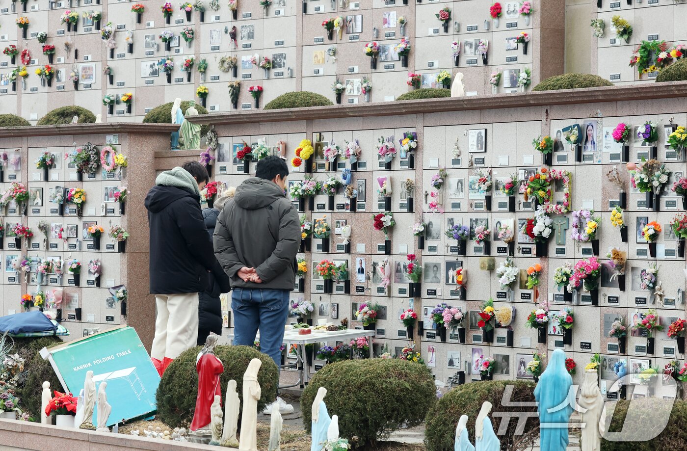 본문 이미지 - 설 연휴를 하루 앞둔 13일 경기 용인시 처인구 천주교용인공원묘원에서 성묘객들이 가족의 묘를 찾아 성묘를 하고 있다. 2026.2.13 ⓒ 뉴스1 김영운 기자