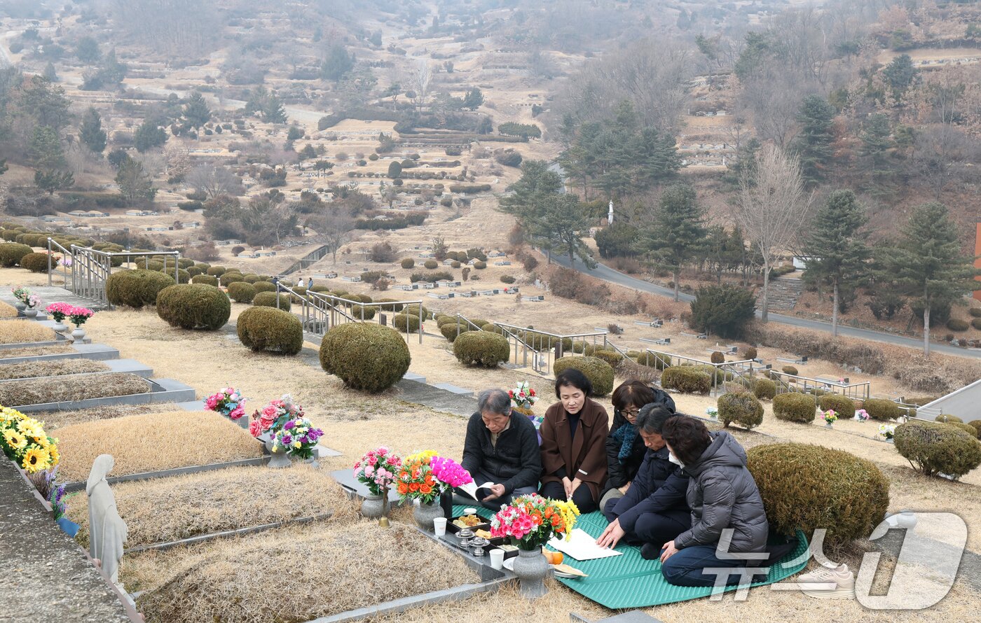 본문 이미지 - 설 연휴를 하루 앞둔 13일 경기 용인시 처인구 천주교용인공원묘원에서 성묘객들이 가족의 묘를 찾아 성묘를 하고 있다. 2026.2.13 ⓒ 뉴스1 김영운 기자