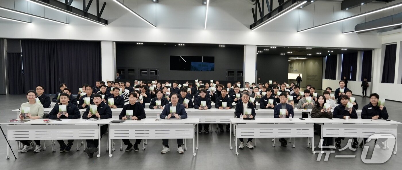 본문 이미지 - 13일 KG모빌리티(KGM) 평택 본사 디자인센터에서 열린 곽재선 KG그룹 회장 북콘서트에서 임직원들이 곽 회장의 두 번째 저서 '곽재선의 창'을 들고 기념 사진을 촬영한 모습. 2026.02.13.