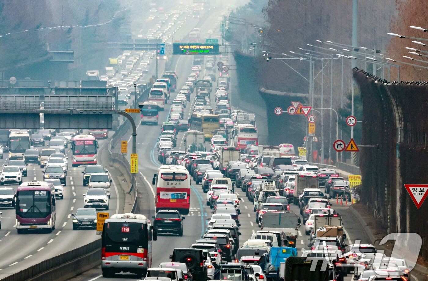 본문 이미지 - 설 연휴를 하루 앞둔 13일 서울 서초구 잠원IC 인근 경부고속도로 하행선이 정체를 빚고 있다. 한국도로공사에 따르면 이날 전국에서 554만 대가 고속도로를 이용하며 수도권에서 지방으로 47만 대, 지방에서 수도권으로 44만 대가 이동할 것이라 밝혔다. 2026.2.13 ⓒ 뉴스1 이호윤 기자