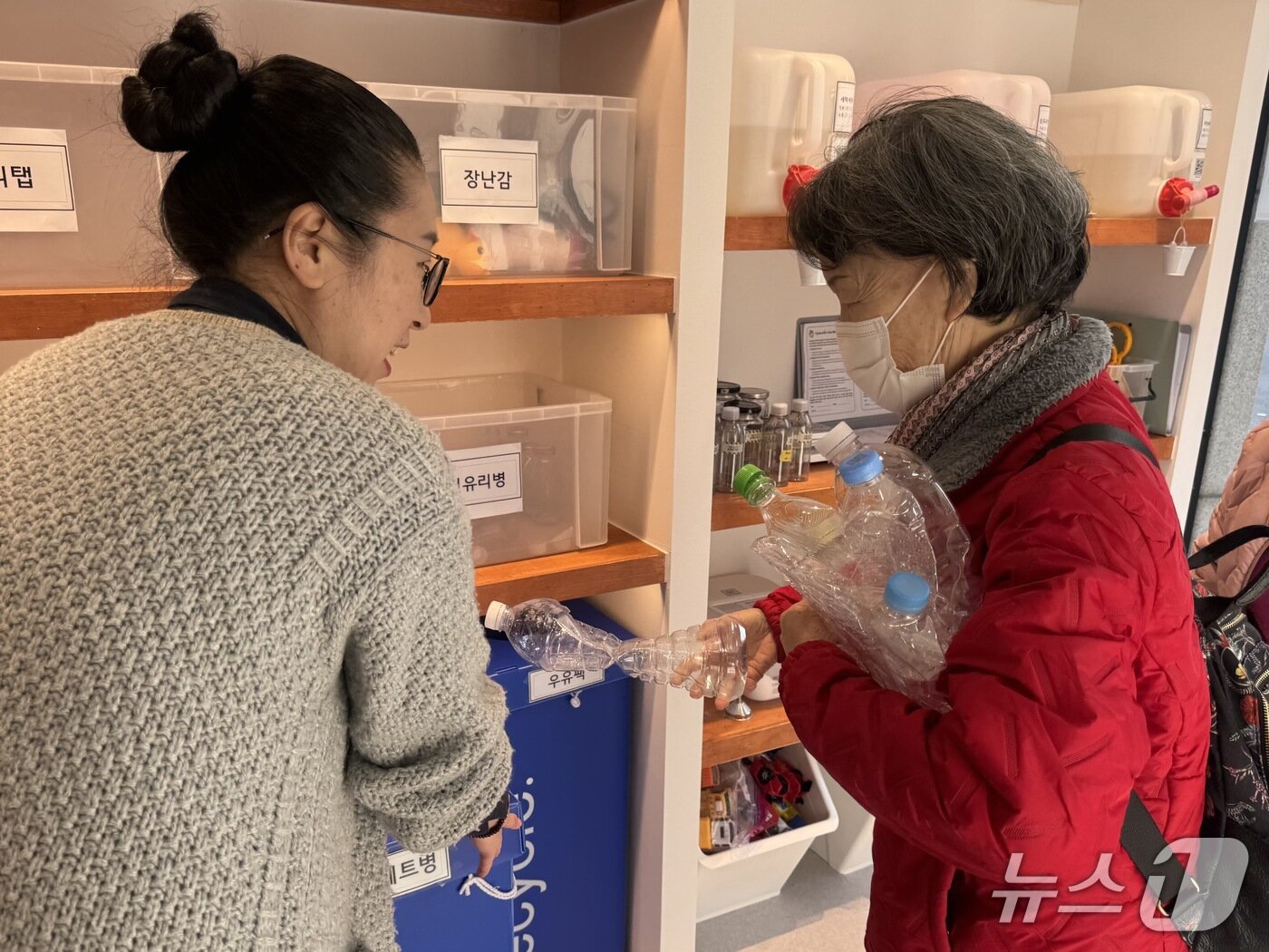 본문 이미지 - 울산 동구 방어진초등학교 앞에 위치한 '안녕 방어진'에서 한 시민이 폐페트병을 전달하고 있다.2026.2.13./뉴스1 ⓒ 뉴스1 김세은 기자