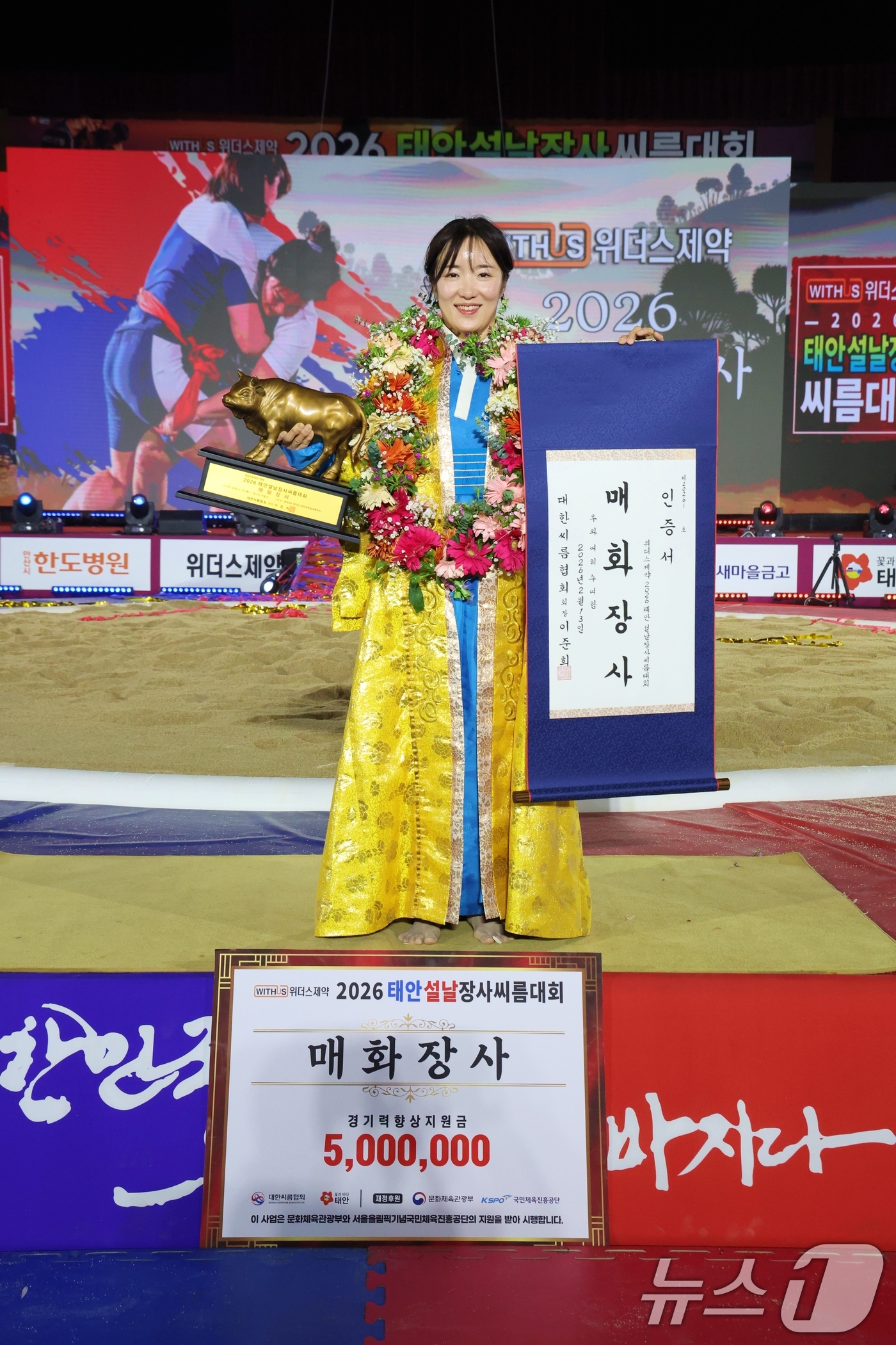 (태안=뉴스1) = 13일 충남 태안군 태안종합실내체육관에서 열린 위더스제약 2026 태안설날장사씨름대회 여자부 개인전에서 매화장사에 등극한 이연우(거제시청)가 황소트로피와 인증서 …