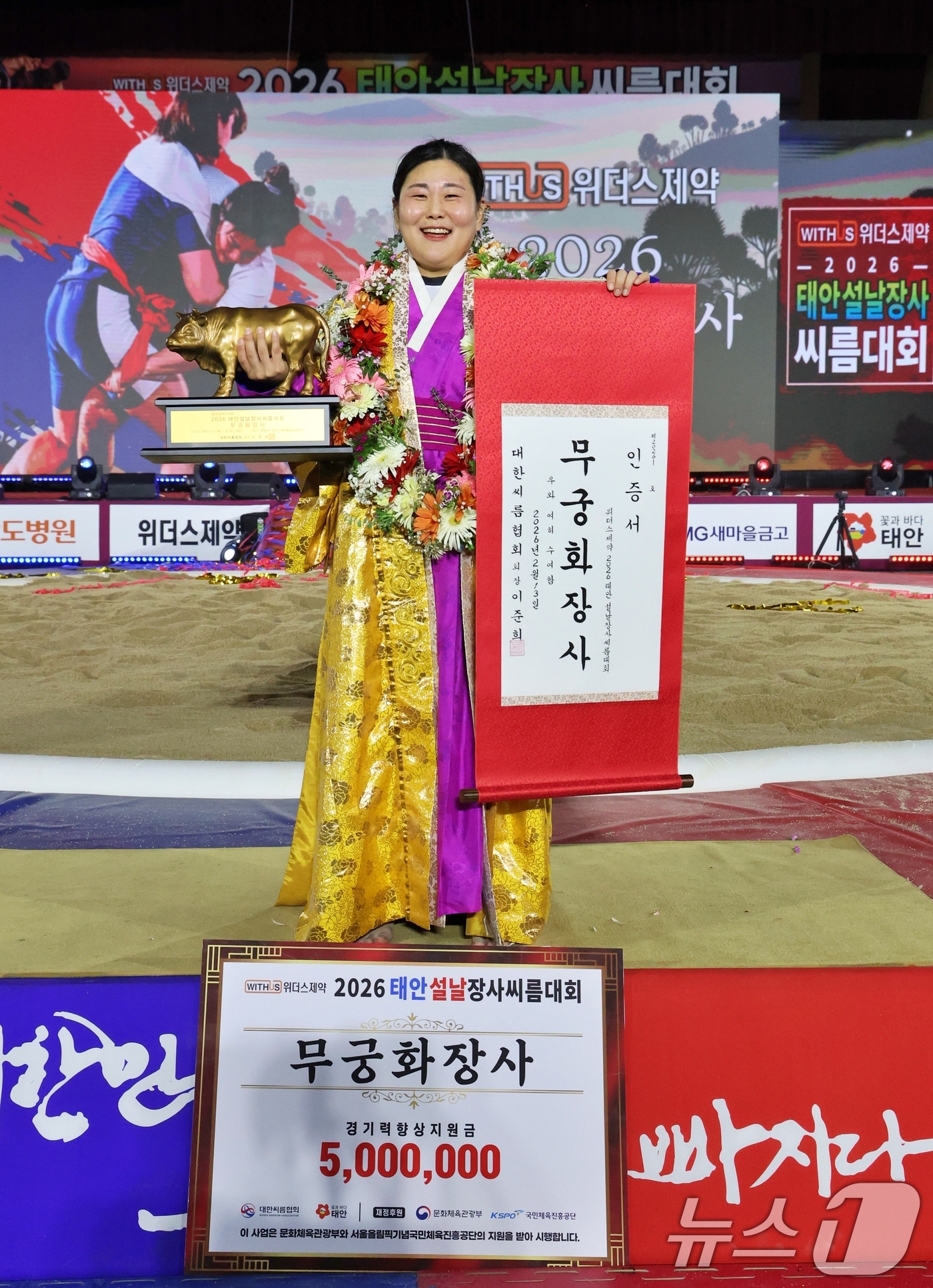 (태안=뉴스1) = 13일 충남 태안군 태안종합실내체육관에서 열린 위더스제약 2026 태안설날장사씨름대회 여자부 개인전에서 무궁화장사에 등극한 김하윤(거제시청)이 황소트로피와 인증 …