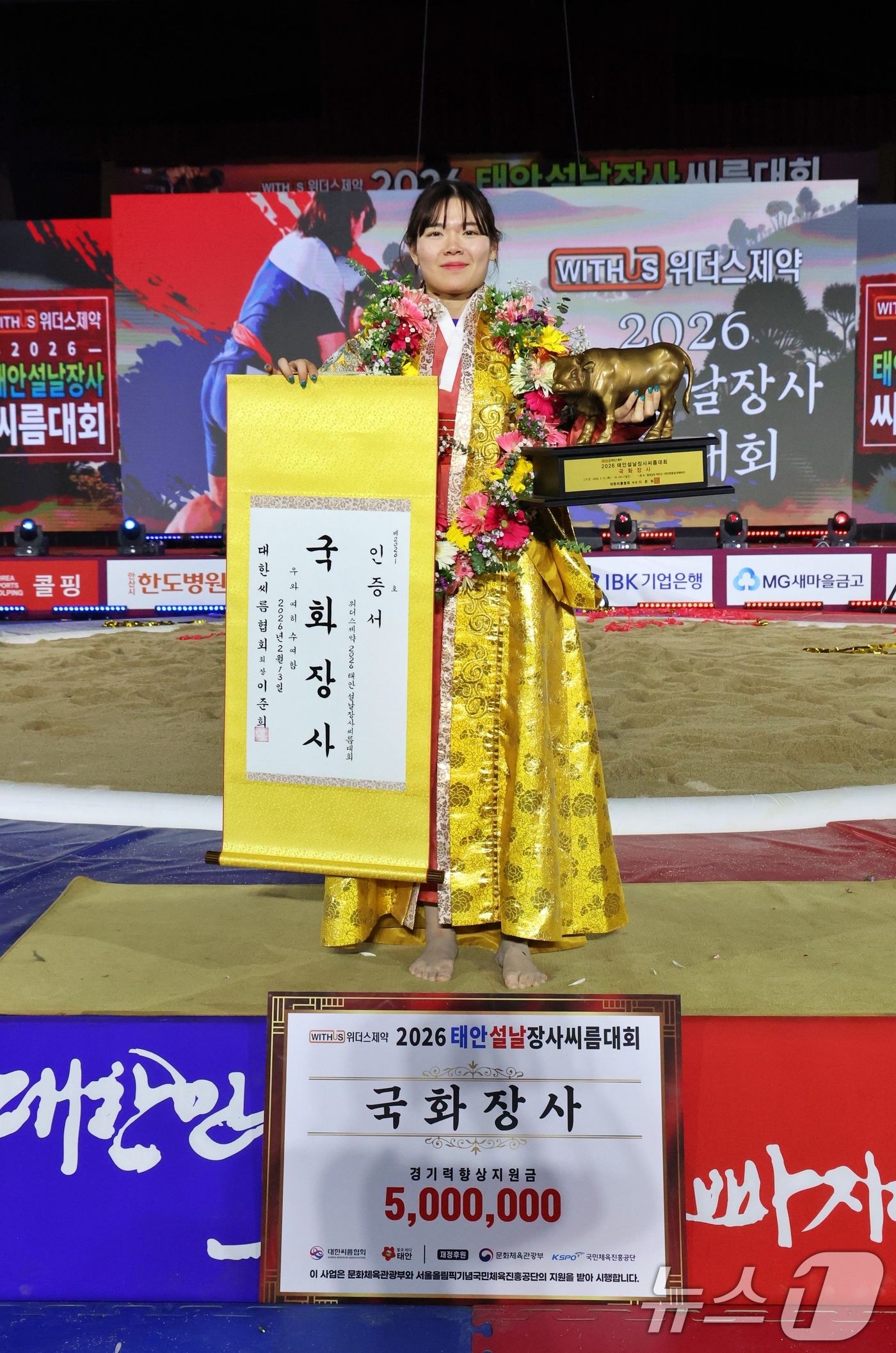 (태안=뉴스1) = 13일 충남 태안군 태안종합실내체육관에서 열린 위더스제약 2026 태안설날장사씨름대회 여자부 개인전에서 국화장사에 등극한 이유나(안산시청)이 황소트로피와 인증서 …