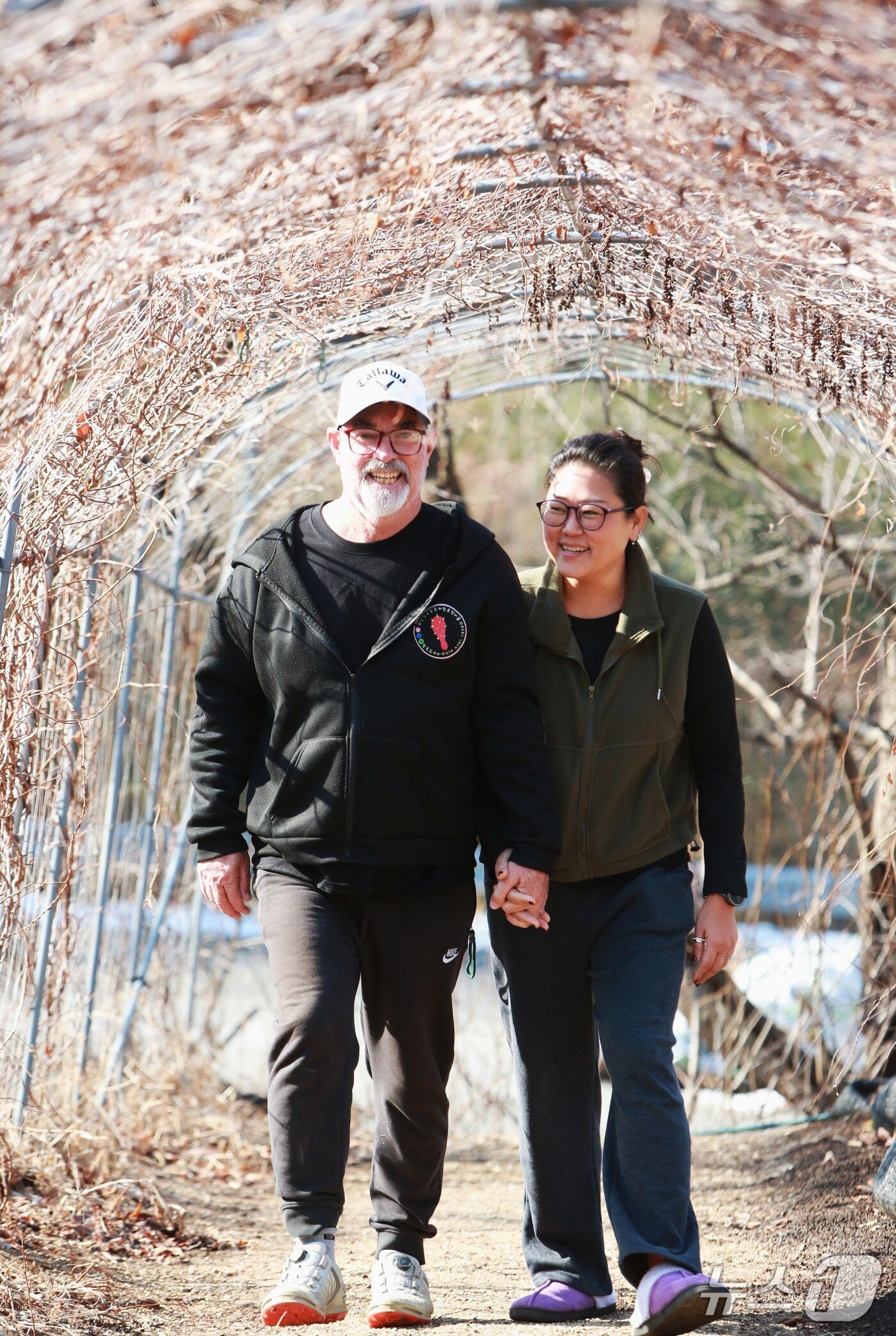 본문 이미지 -  PGA 프로 골퍼 호주 출신인 토니 말로니와 아내 봉지현 씨가 오미자 넝쿨에서 산책을 하고 있다. /2026.2.16/뉴스1 손도언 기자 