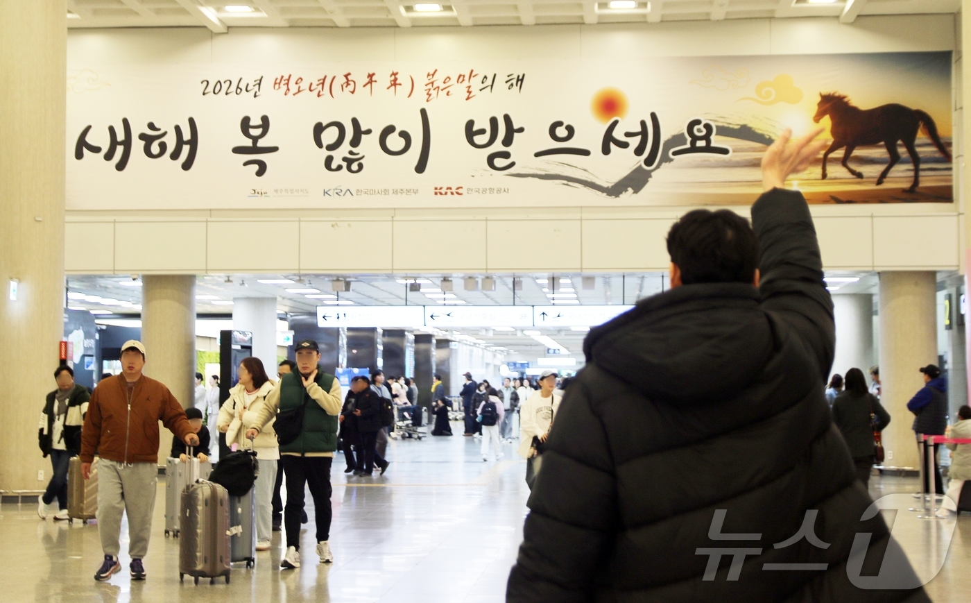 (제주=뉴스1) 홍수영 기자 = 설 연휴가 시작된 14일 오전 제주국제공항 1층에서 시민이 손을 흔들며 인사하고 있다.제주도관광협회에 따르면 이번 연휴 동안 제주도에는 입도객 24 …