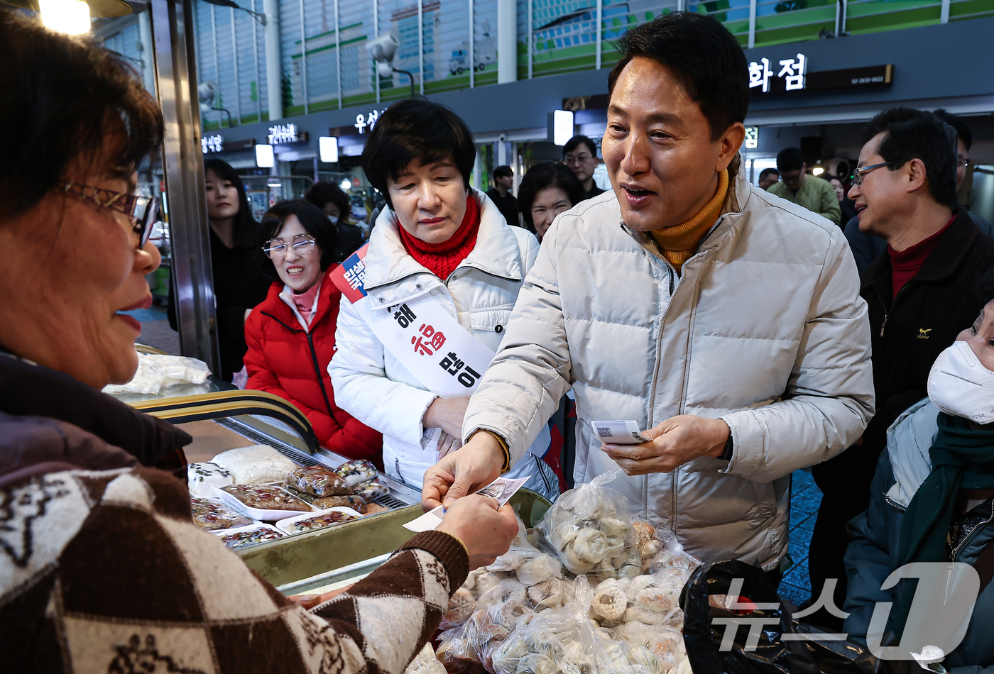 (서울=뉴스1) 김도우 기자 = 오세훈 서울시장이 설 연휴 첫날인 14일 서울 영등포전통시장을 찾아 떡을 구입하고 있다. 2026.2.14/뉴스1