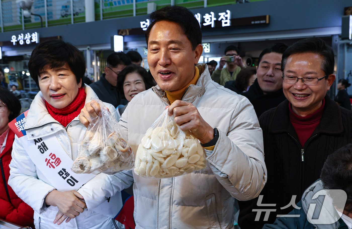 (서울=뉴스1) 김도우 기자 = 오세훈 서울시장이 설 연휴 첫날인 14일 서울 영등포전통시장을 찾아 떡을 구입하고 있다. 2026.2.14/뉴스1