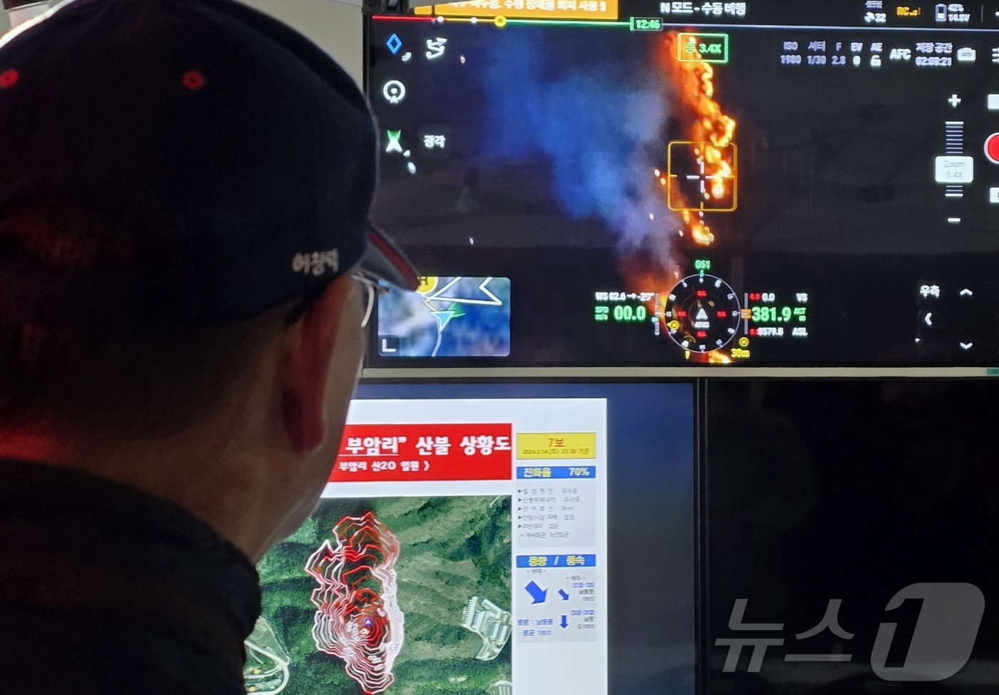 (금산=뉴스1) 이시우 기자 = 14일 충남 금산군 진산면 백마산에서 발생한 산불 현장지휘소에서 산림청 관계자가 드론으로 촬영한 산불 현장 영상을 지켜보고 있다. 2026.2.15 …