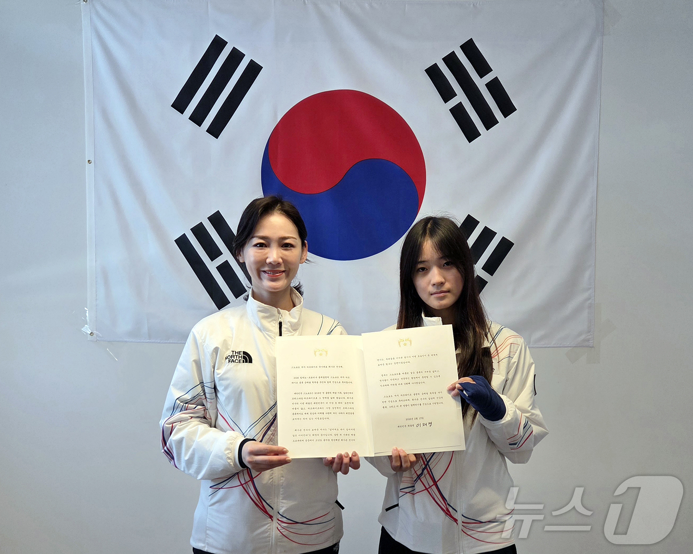 (밀라노=뉴스1) 김진환 기자 = 스노보드 여자 하프파이프에서 금메달을 획득한 최가온이 15일(현지시간) 이탈리아 밀라노에서 이수경 선수단장에게 이재명 대통령 축전을 받은 뒤 기념 …