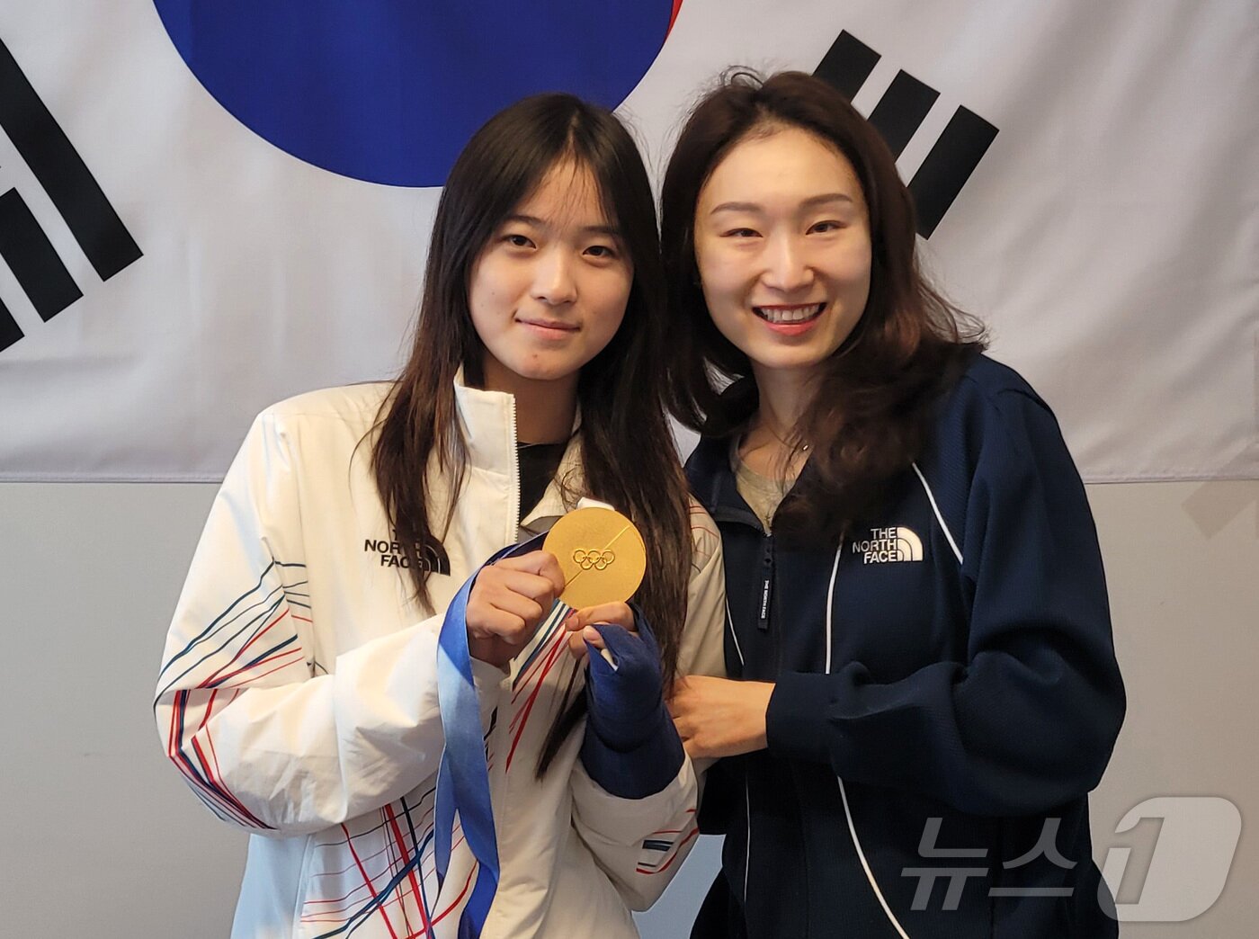 본문 이미지 - 스노보드 하프파이프에서 금메달을 획득한 최가온이 15일(현지시간) 이탈리아 밀라노 선수촌 대한민국 선수단 사무실에서 쇼트트랙 최민정을 만나 기념촬영을 하고 있다. (대한체육회 제공. 재판매 및 DB 금지) 2026.2.15 ⓒ 뉴스1