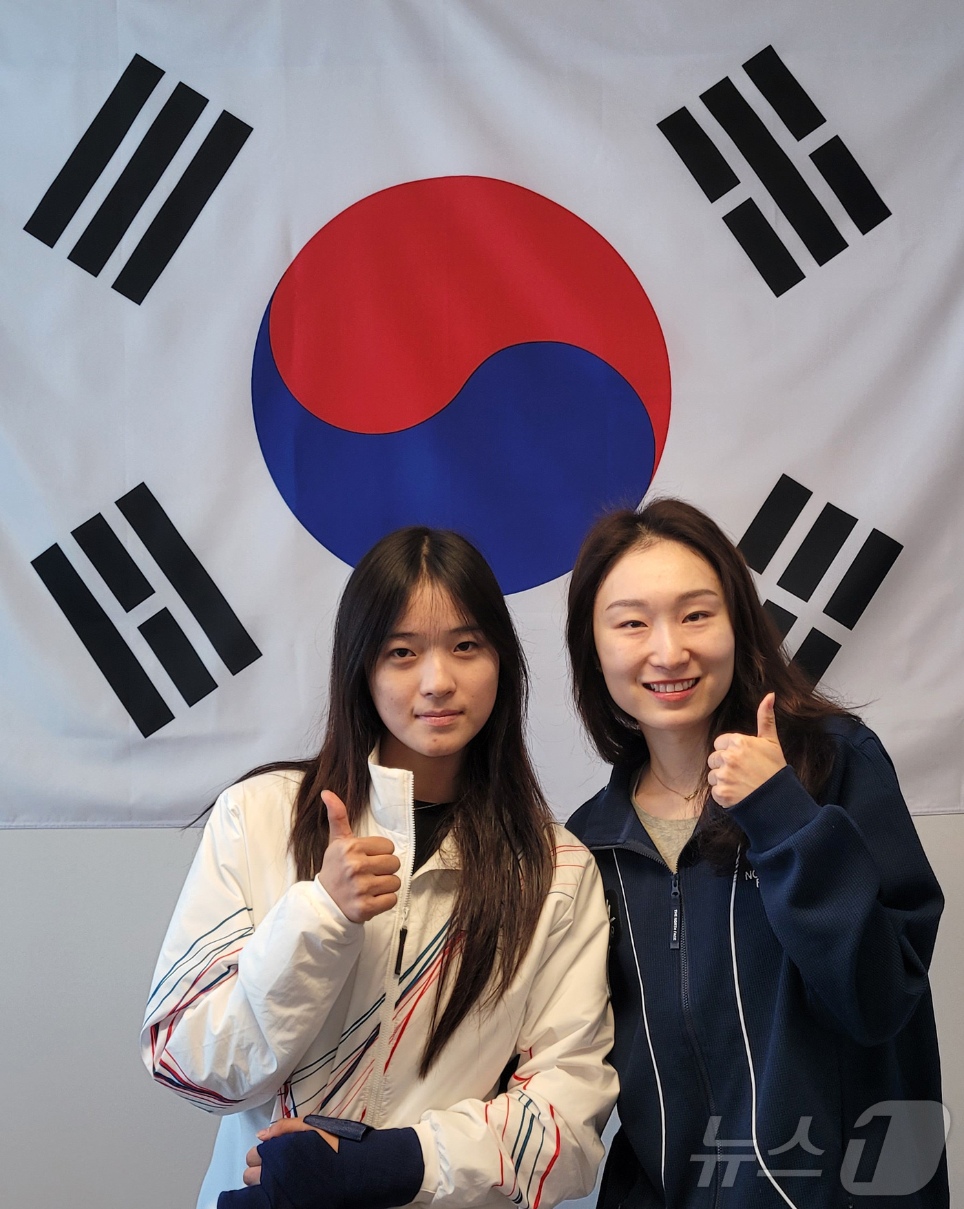 (밀라노=뉴스1) = 스노보드 하프파이프에서 금메달을 획득한 최가온이 15일(현지시간) 이탈리아 밀라노 선수촌 대한민국 선수단 사무실에서 쇼트트랙 최민정을 만나 기념촬영을 하고 있 …