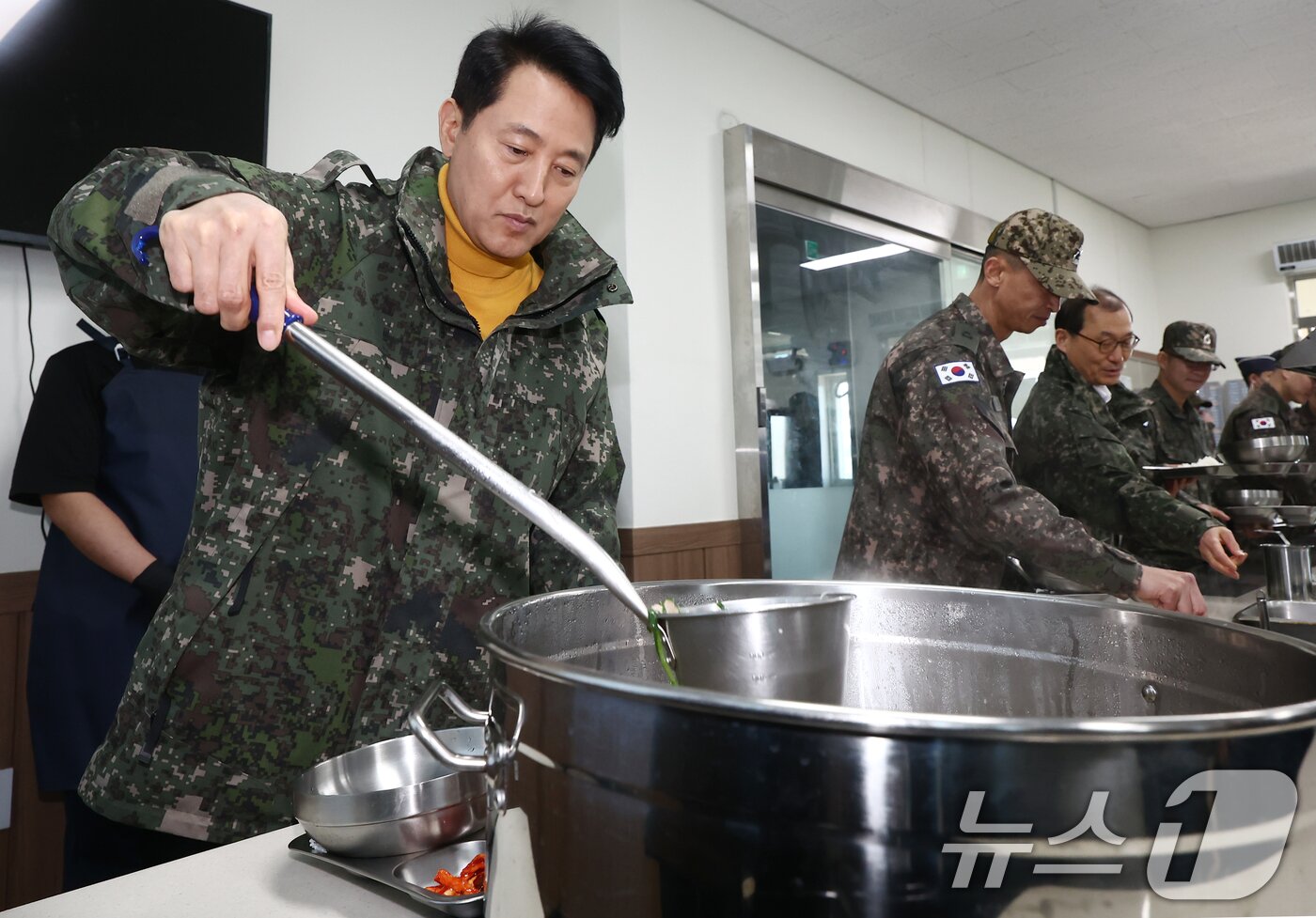 본문 이미지 - 오세훈 서울시장이 설 연휴인 16일 오후 서울 1방공여단 방공진지를 방문, 군 장병들과 식사를 하기 위해 배식을 받고 있다. 2026.2.16 ⓒ 뉴스1 김민지 기자