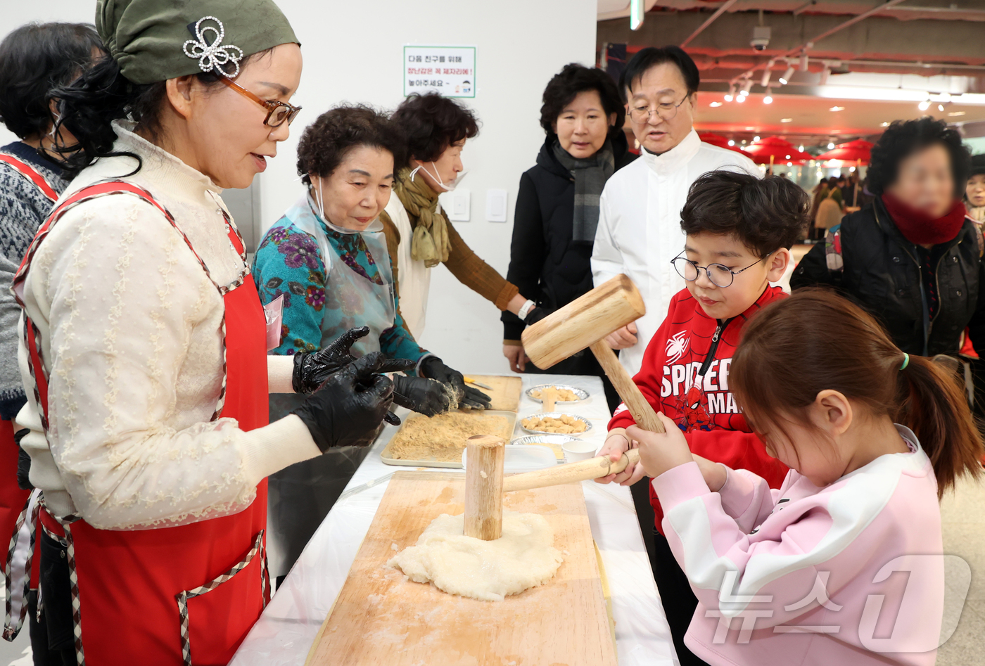 (서울=뉴스1) = 민족 최대명절인 설날을 하루 앞둔 16일 서울 동작구 동작구청 동작스타파크에 만들어진 민속놀이 체험행사장을 찾은 어린이들이 인절미 만들기 위해 떡메치기를 하고 …