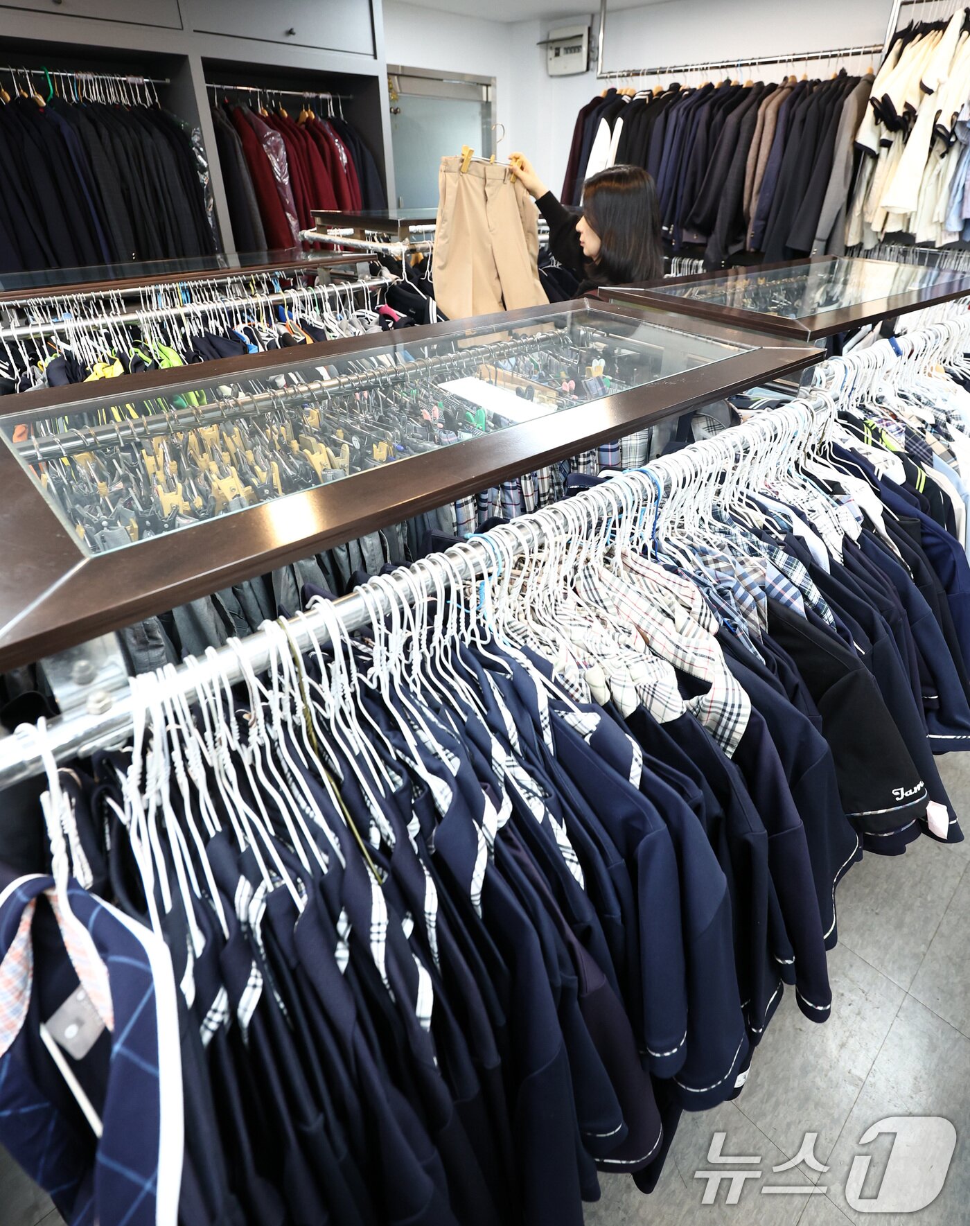 본문 이미지 - 오는 20일 '교복 제도 관련 부처별 대응 방안'을 주제로 정부 합동 회의를 앞둔 19일 서울 송파구 나눔교복매장에서 관계자가 교복을 정리하고 있다.  2026.2.19 ⓒ 뉴스1 최지환 기자