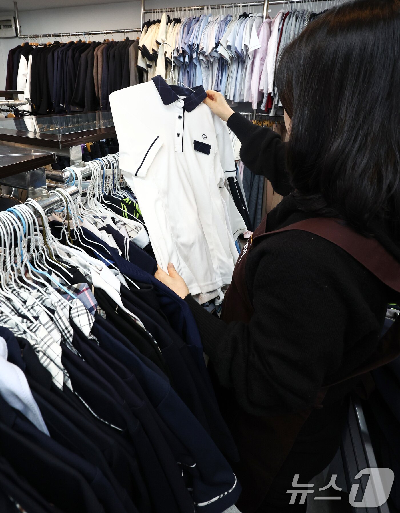 본문 이미지 - 오는 20일 '교복 제도 관련 부처별 대응 방안'을 주제로 정부 합동 회의를 앞둔 19일 서울 송파구 나눔교복매장에서 관계자가 교복을 정리하고 있다.  2026.2.19 ⓒ 뉴스1 최지환 기자