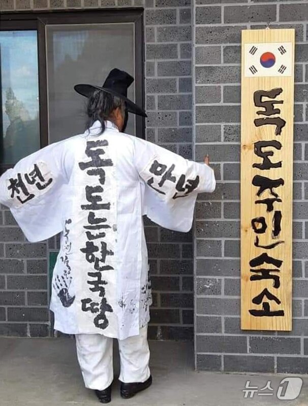 본문 이미지 - 독도서예가 김동욱씨가 19일 경북 포항시 북구 동빈항에서 일본 정부의 다케시마의 날에 항의하는 독도 주민 현판 퍼포먼스를 펼쳤다. (서예가 김동욱씨 제공, 재핀매 및 DB금지) 2026.2.19 ⓒ 뉴스1 최창호 기자