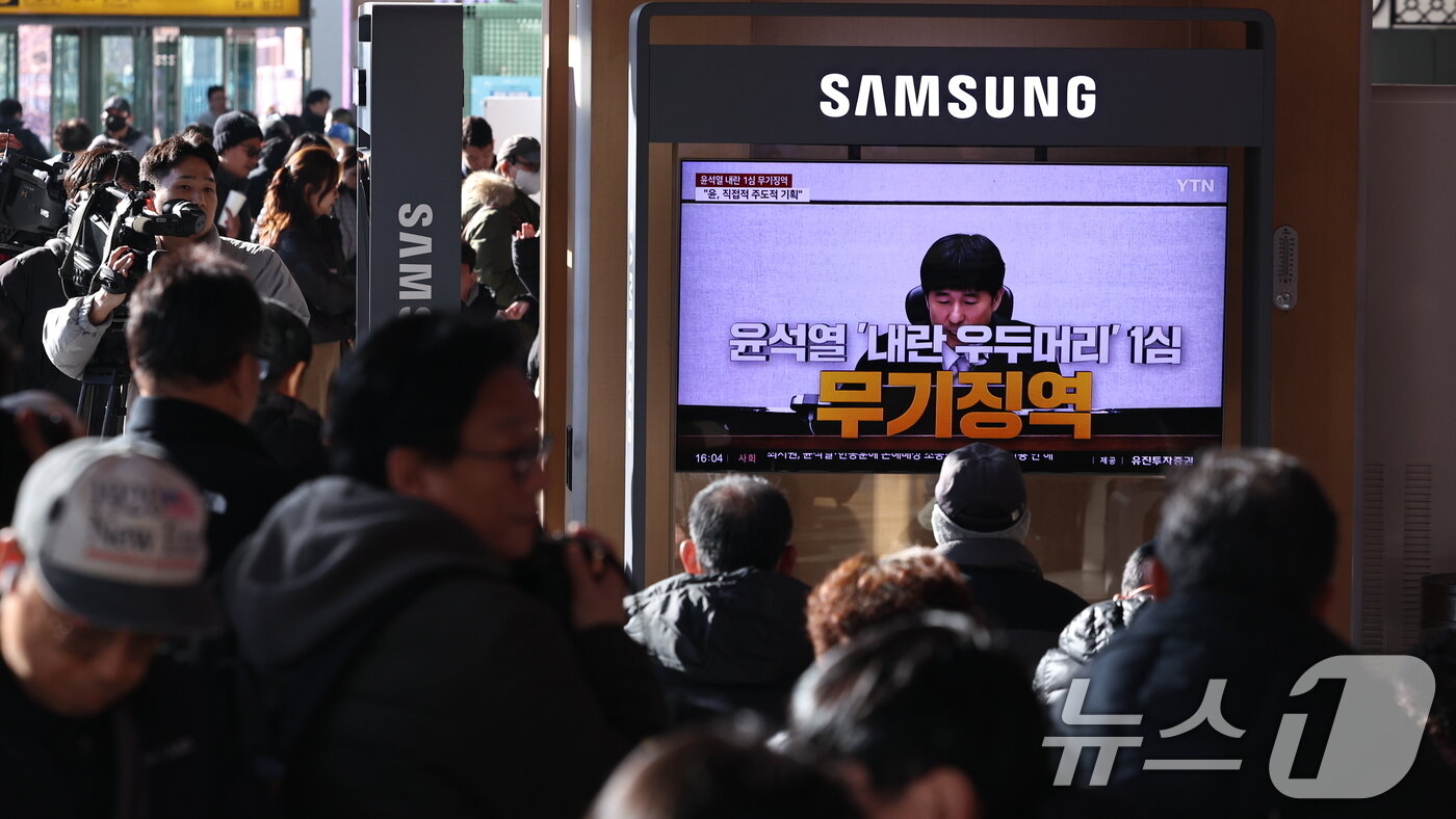 본문 이미지 - 19일 오후 서울역 대합실에 설치된 TV를 통해 윤석열 전 대통령의 내란 우두머리 혐의 1심 선고가 생중계 되고 있다. 윤 전 대통령은 2024년 12월 3일 비상계엄을 선포한 지 443일 만에 무기징역을 선고받았다. 2026.2.19 ⓒ 뉴스1 구윤성 기자