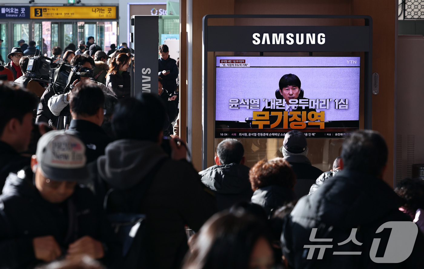 (서울=뉴스1) 구윤성 기자 = 19일 오후 서울역 대합실에 설치된 TV를 통해 윤석열 전 대통령의 내란 우두머리 혐의 1심 선고가 생중계 되고 있다. 윤 전 대통령은 2024년 …