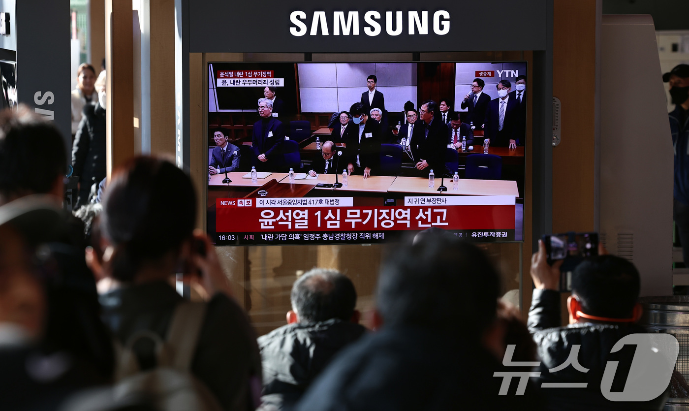 (서울=뉴스1) 구윤성 기자 = 19일 오후 서울역 대합실에 설치된 TV를 통해 윤석열 전 대통령의 내란 우두머리 혐의 1심 선고가 생중계 되고 있다. 윤 전 대통령은 2024년 …