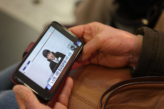 핸드폰으로 윤석열 1심 선고 지켜보는 광주시민