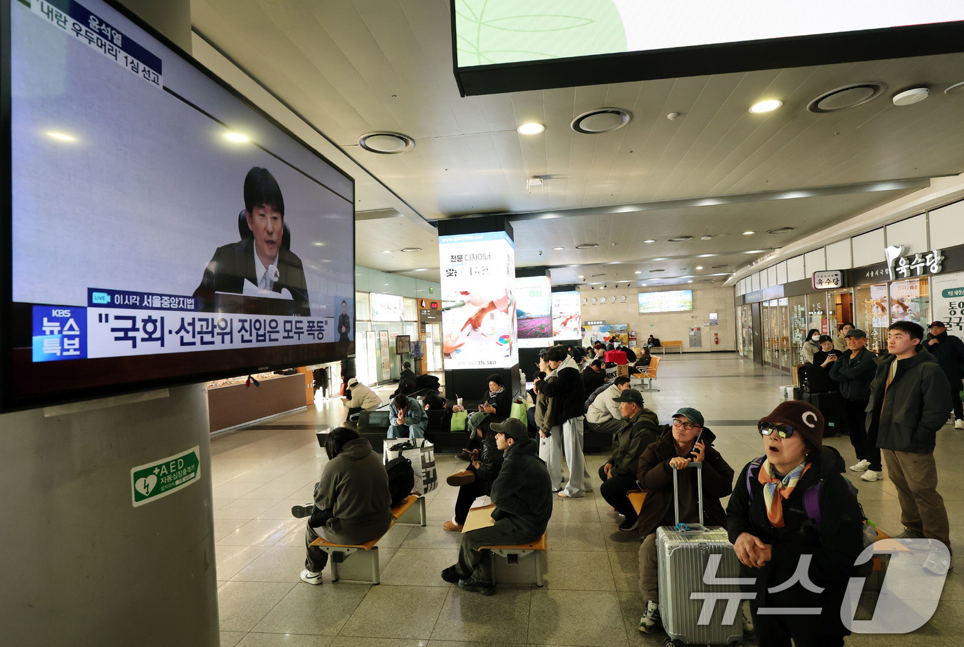 (광주=뉴스1) 박지현 기자 = 19일 오후 광주 서구 광천동 유스퀘어복합터미널에서 시민들이 윤석열 전 대통령의 내란 우두머리 혐의 1심 선고를 지켜보고 있다. 윤 전 대통령은 2 …