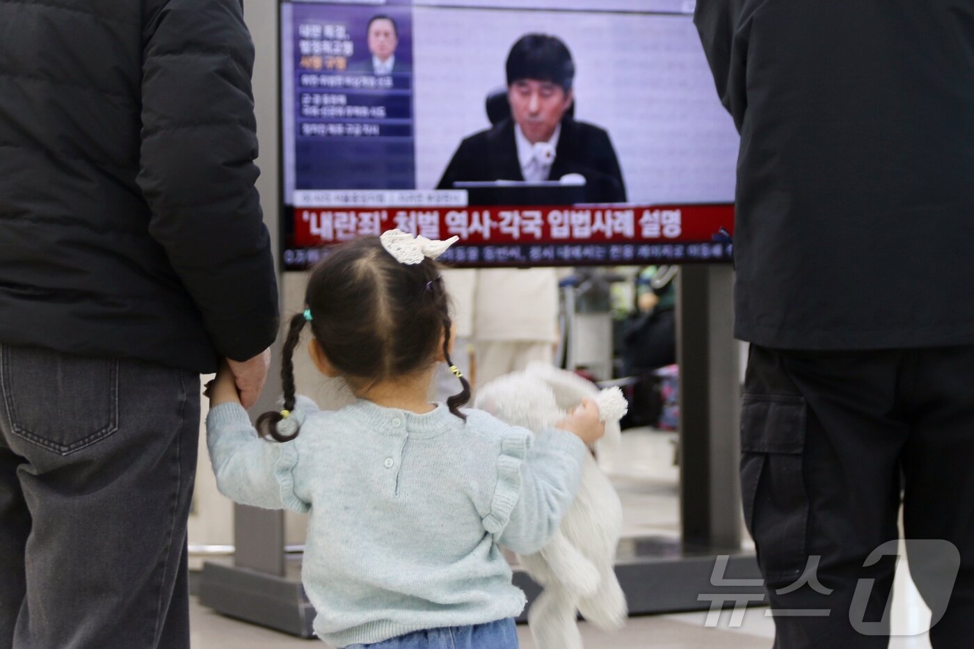 본문 이미지 - 19일 오후 제주국제공항 3층 출발장에서 여행객들이 윤석열 전 대통령의 내란 우두머리 혐의에 대한 1심 선고를 지켜보고 있다.2026.2.19 ⓒ 뉴스1 홍수영 기자