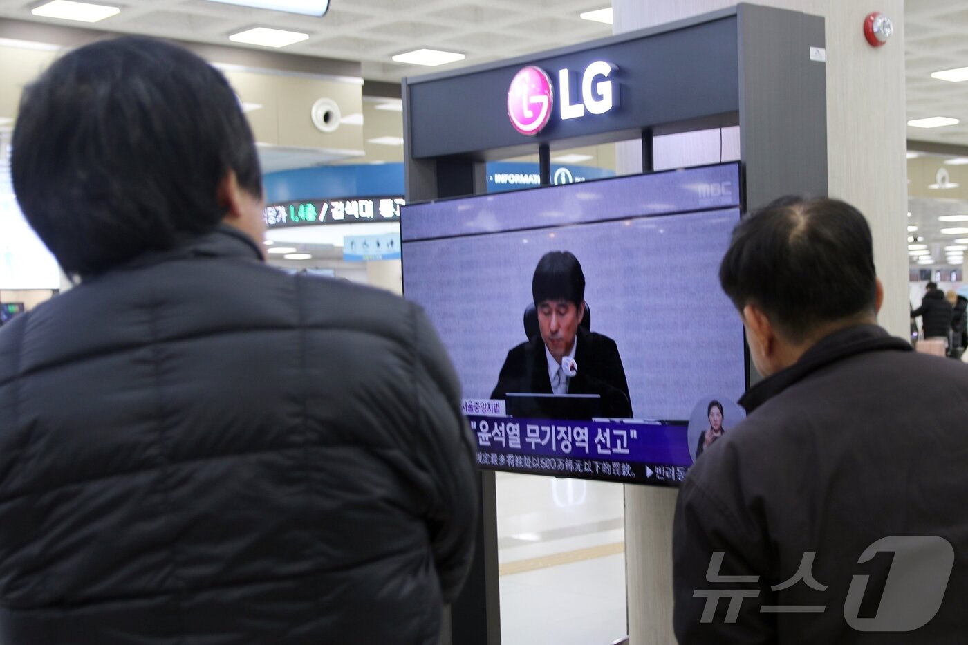 본문 이미지 - 19일 오후 제주국제공항 3층 출발장에서 여행객들이 윤석열 전 대통령의 내란 우두머리 혐의에 대한 1심 선고를 지켜보고 있다.2026.2.19 ⓒ 뉴스1 홍수영 기자