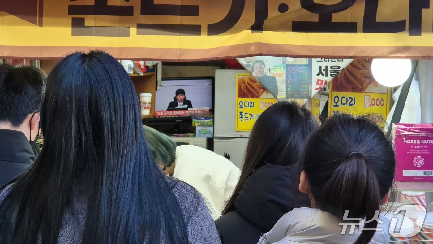 본문 이미지 - 19일 오후 3시 울산 중구 중앙전통시장에서 시민들이 내란재판 선고 생중계를 지켜보고 있다.2026.2.19.ⓒ 뉴스1 박정현 기자
